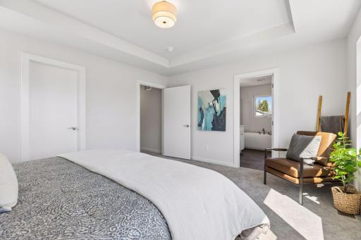 Primary suite with generous space, soft natural light, and direct access to private ensuite bath. Includes a walk-in closet and is designed for comfort and everyday living.