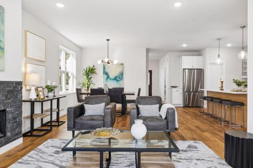 Spacious open-concept living room with large windows, abundant natural light, and seamless connection to dining and kitchen areas- perfect for entertaining and everyday living.