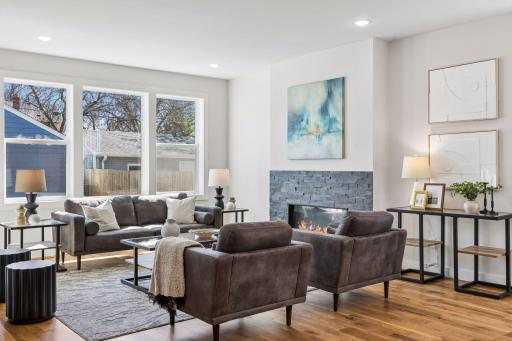 Elegant living area centered around a sleek gas fireplace with contemporary stone surround, creating a cozy yet modern focal point.