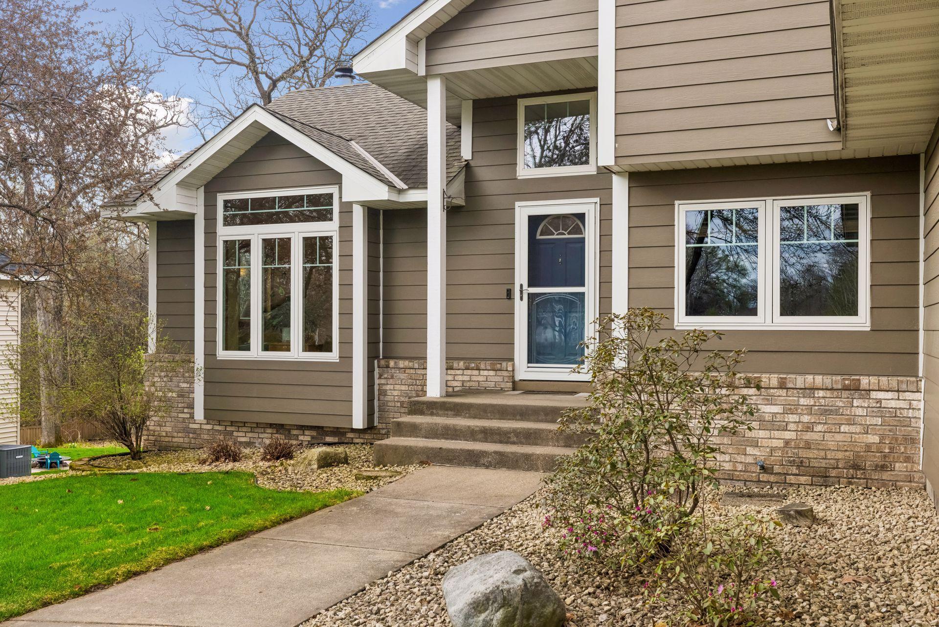 Inviting front step with transom window above, bringing in extra natural light to the foyer.