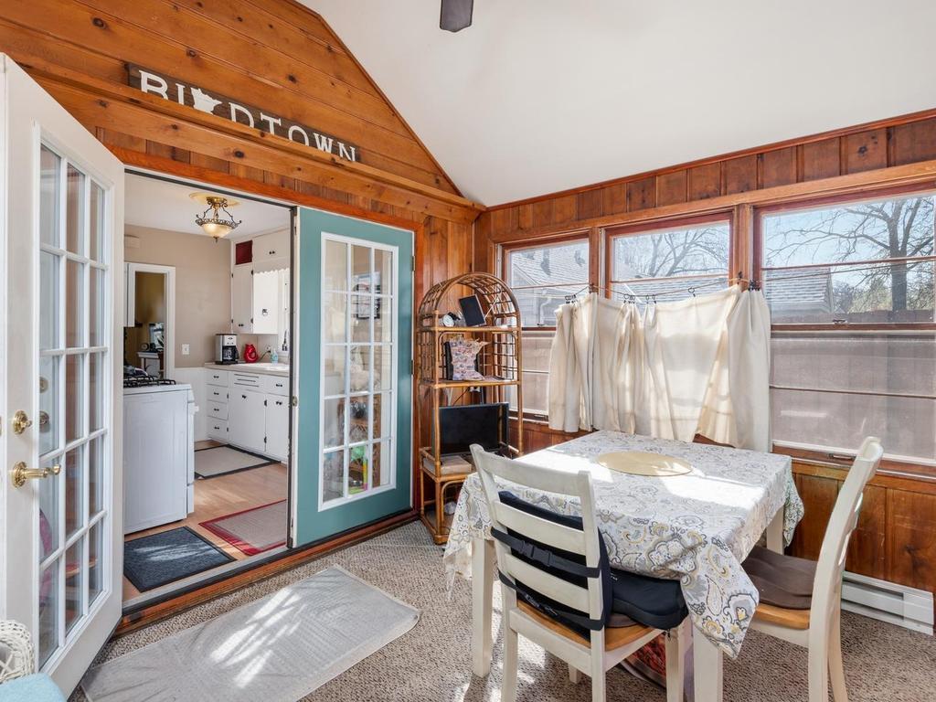 Vaulted Sunroom has a ceiling fan and exterior door to fenced backyard.