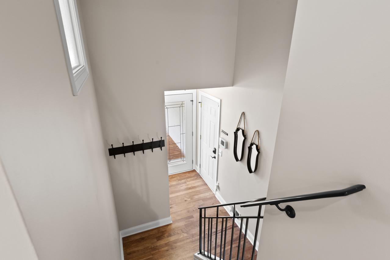 Welcoming foyer with soaring ceilings, abundant natural light, and an open staircase creating a bright and inviting first impression.
