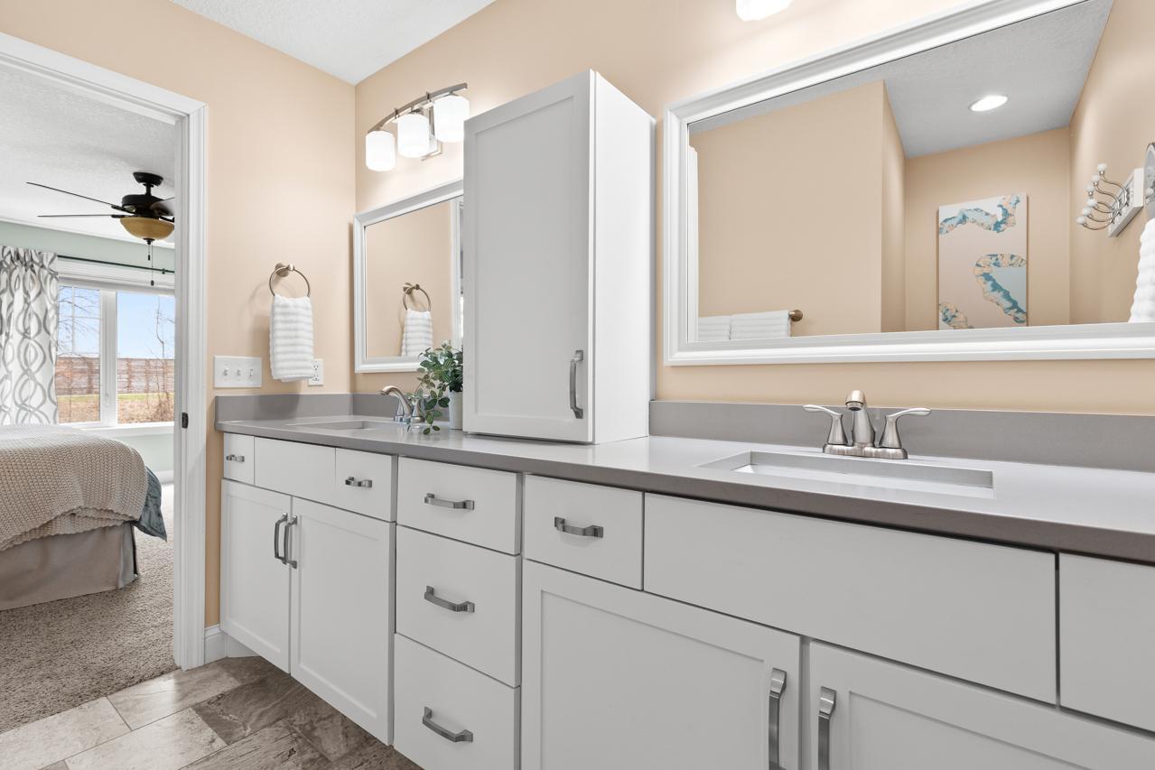 Private 3/4 primary bath featuring quartz countertops, dual sinks, and a walk-in shower.