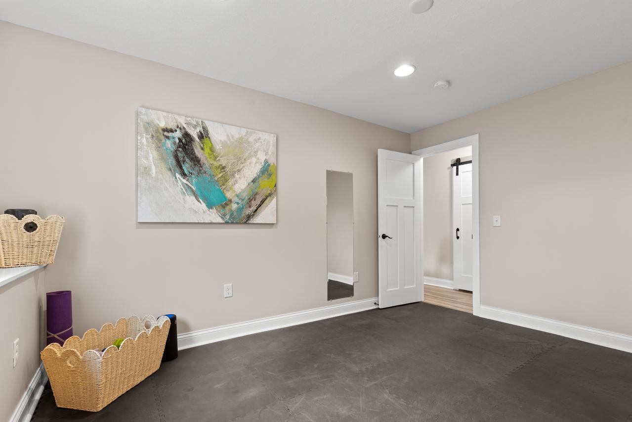 Fifth bedroom on the lower level, currently used as a home gym, offering flexible space to suit your needs.