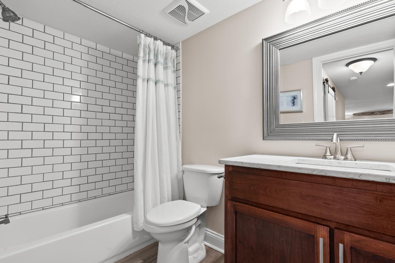 Additional lower-level bathroom featuring a tiled shower/tub combination and stylish vanity.