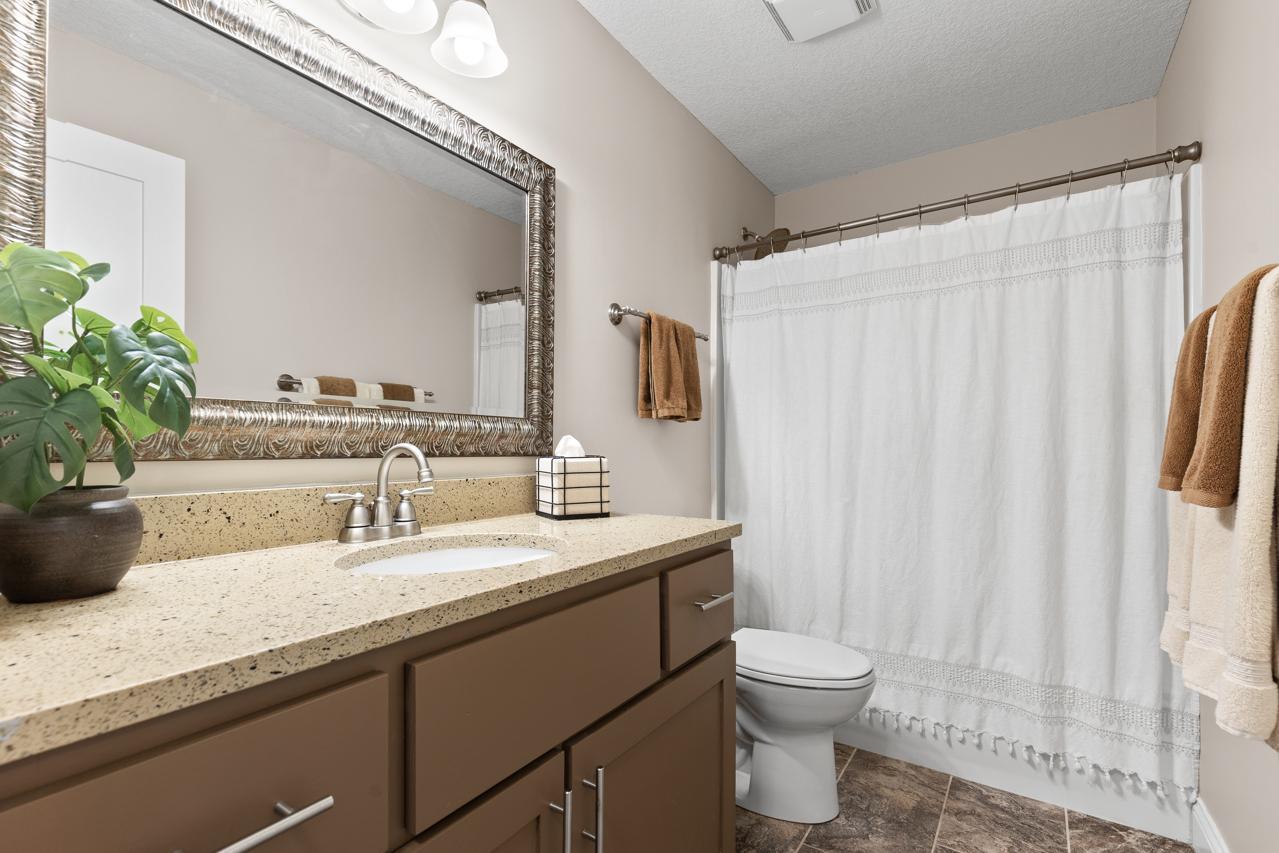 Lower-level full bathroom featuring a spacious vanity and convenient access to surrounding living areas.