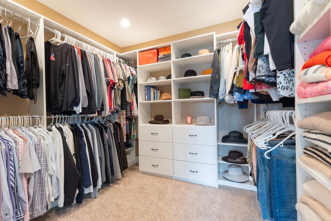 Large walk-in closet with custom built-ins, shelving, and ample hanging space for organized storage.