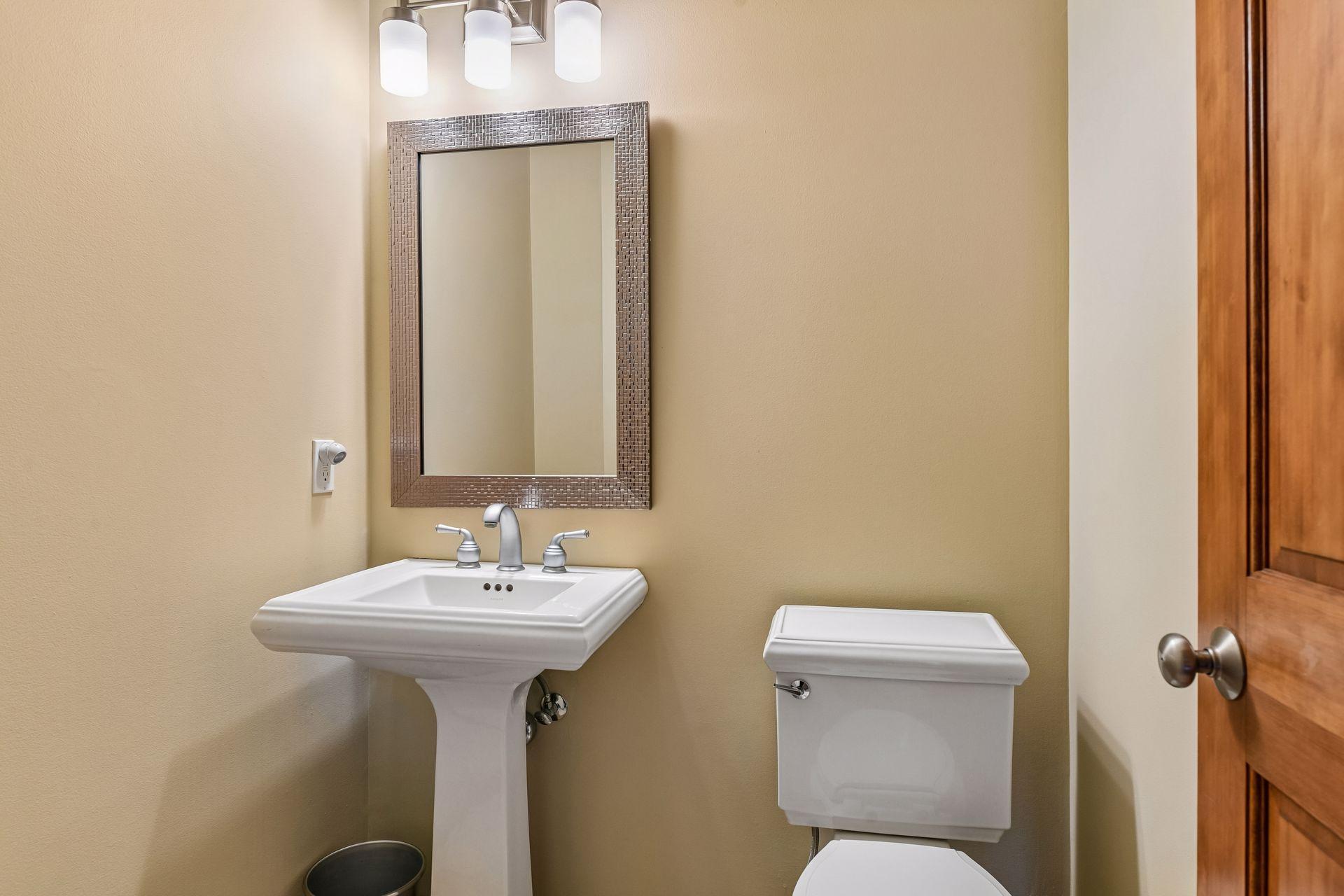 The main level Powder Room features Kohler fixture, a designer mirror and updated lighting.