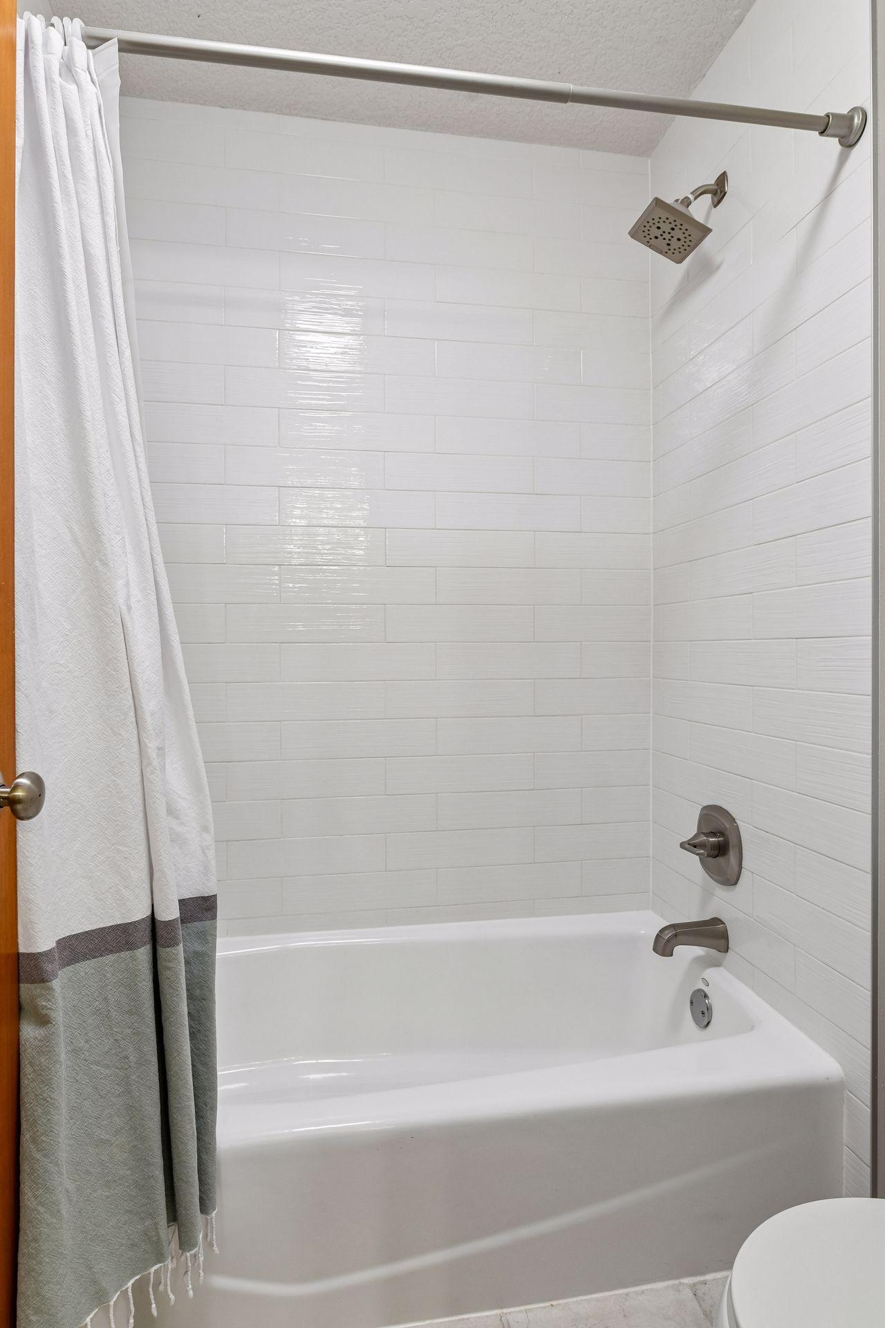 The bath offers a new subway tiled surround.