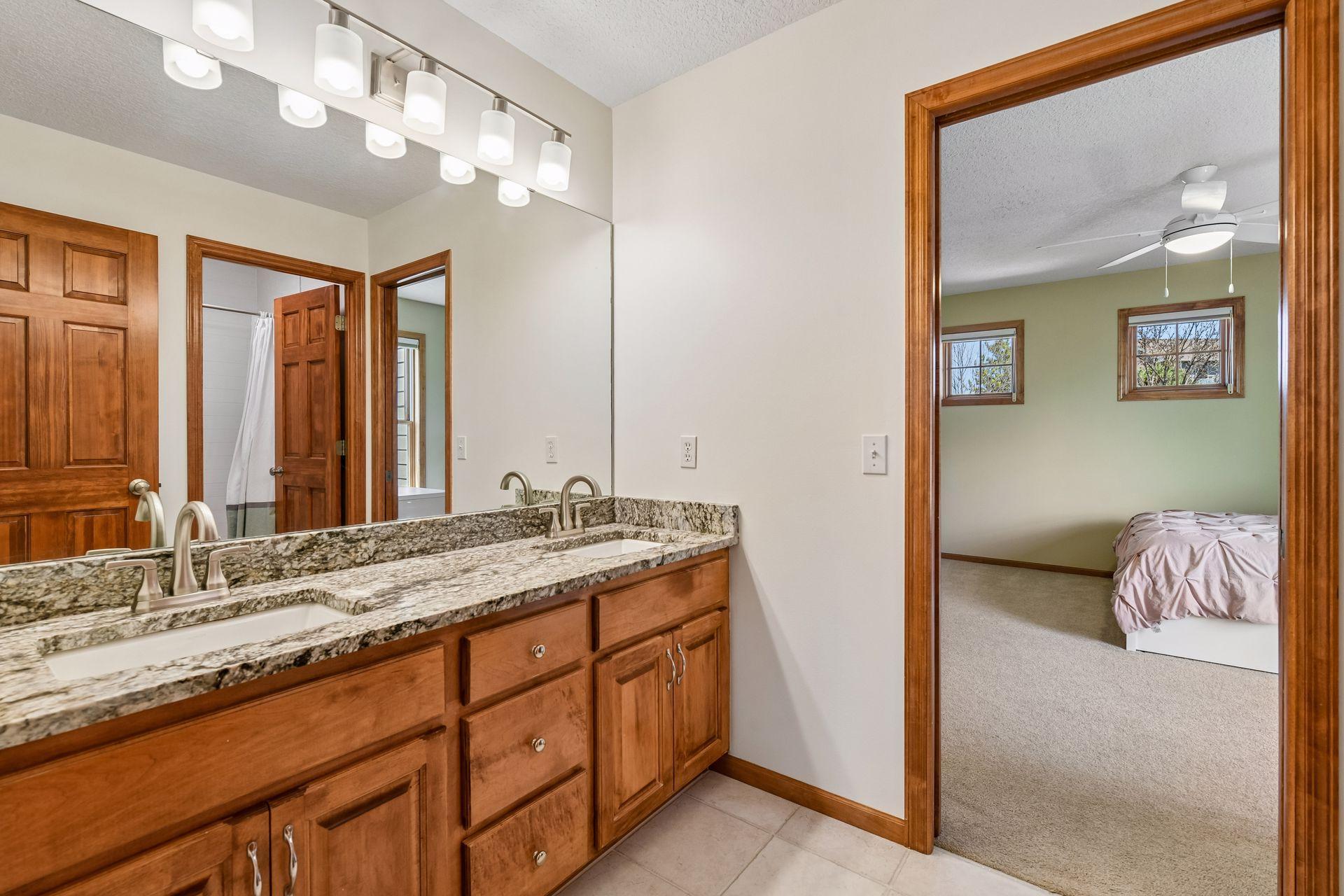 Two of the Junior Bedrooms share a full, jack-and-jill bathroom with tiled flooring and updated granite countertops.