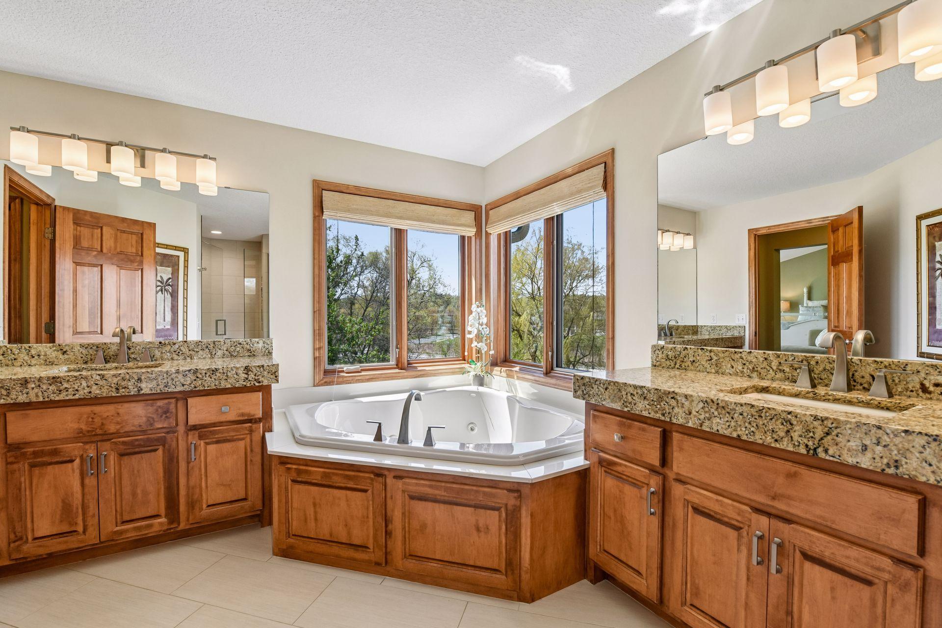 The Primary Suite has been updated with granite countertops, new fixtures and a large jetted bathtub.