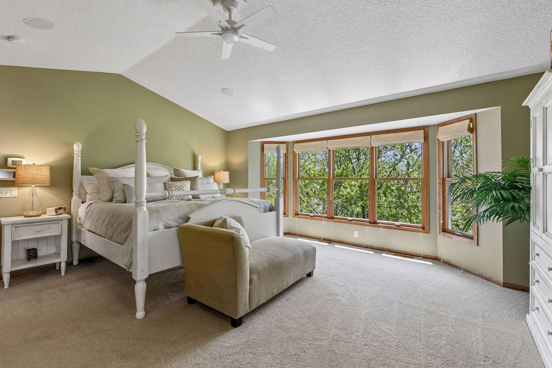 A tranquil retreat - the Primary Suite enjoys views of the treetops and pond.