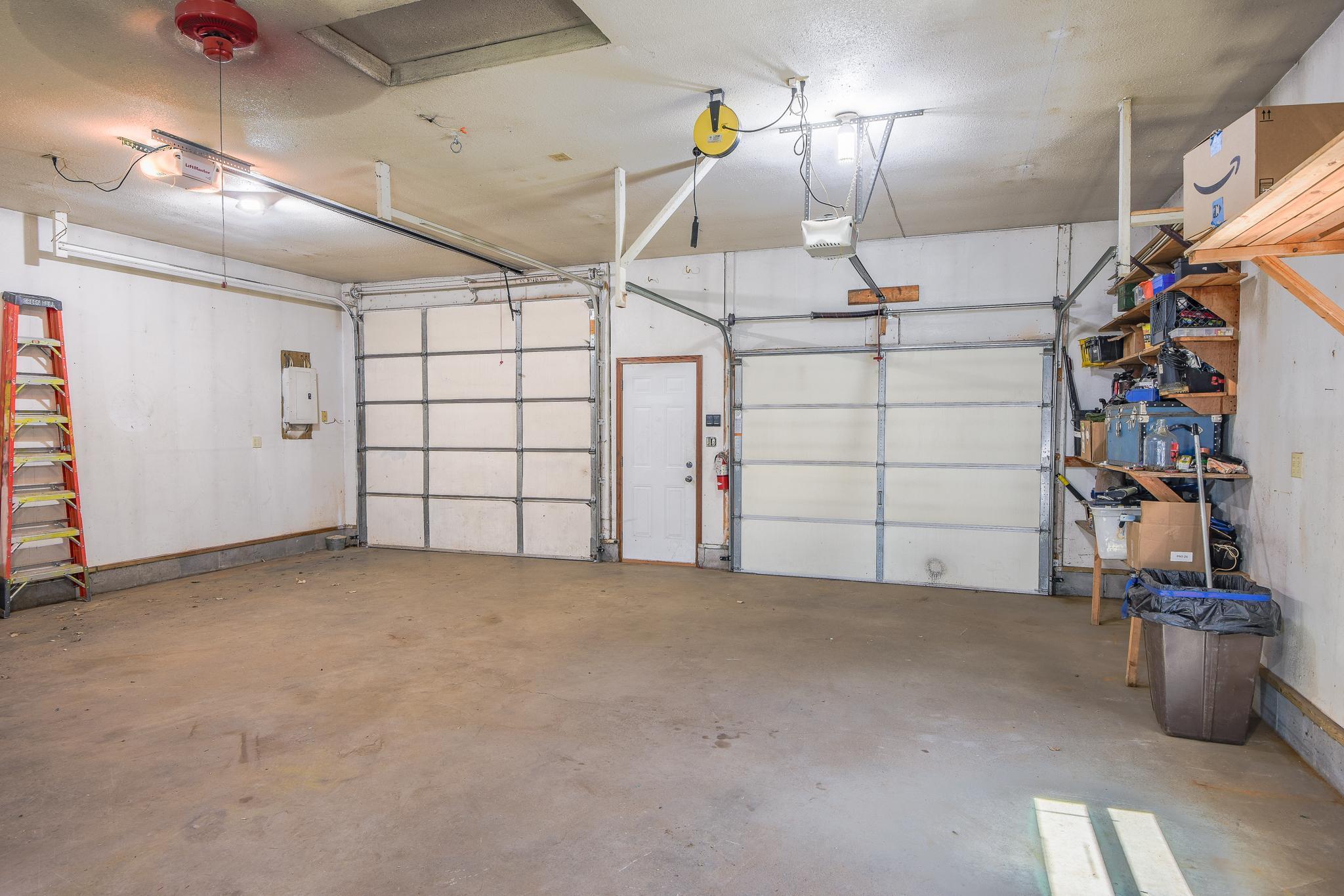 Well kept garage with built in shelving.