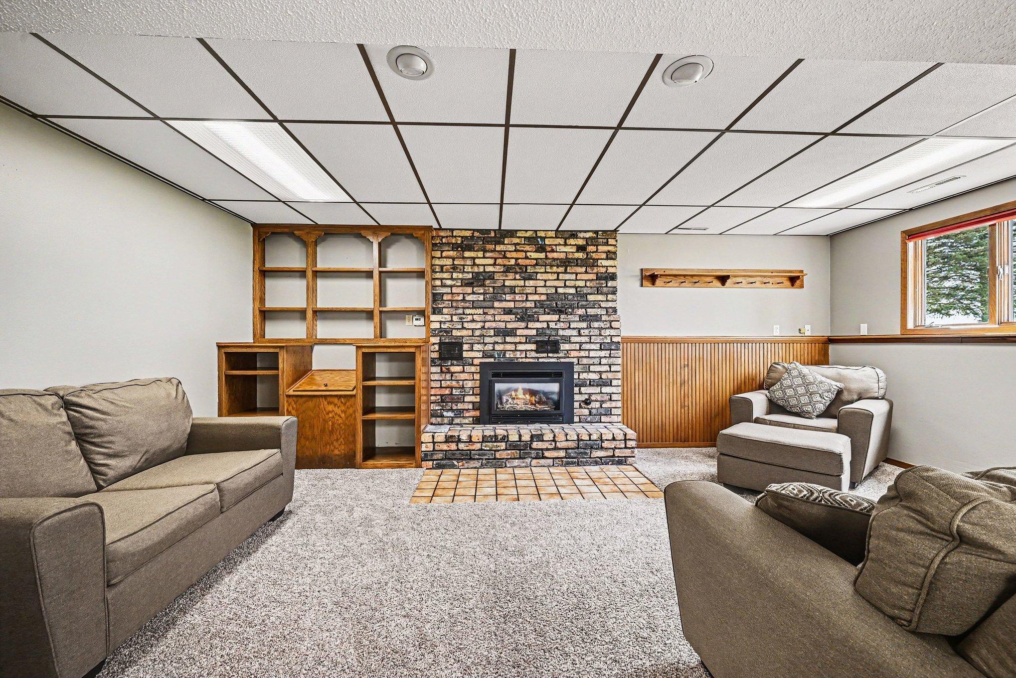 Finished lower level with brick gas fireplace and custom built-ins