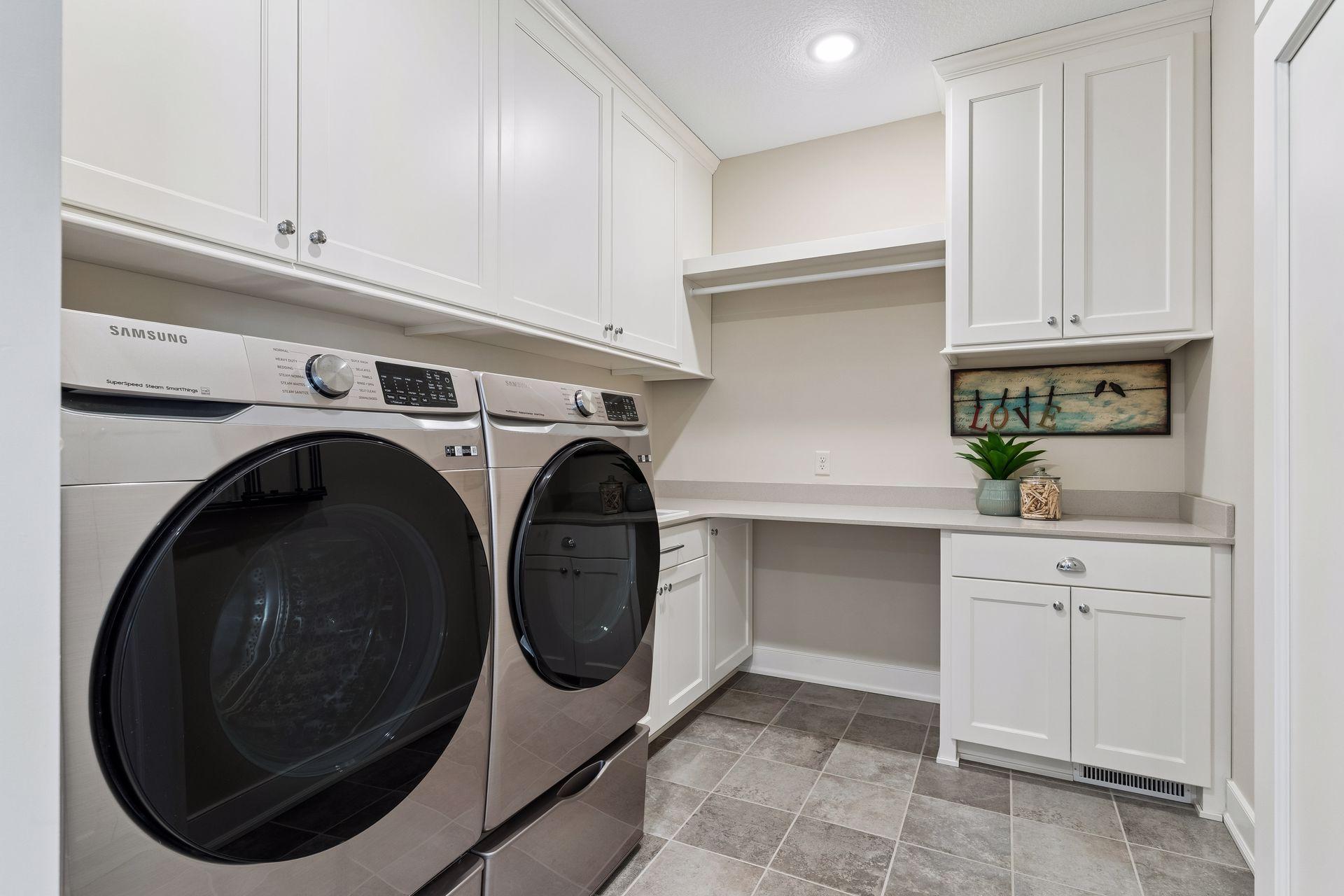 A spacious main-floor laundry room adds everyday convenience with generous cabinetry, folding space, built-in storage, and a functional layout designed to keep the home running smoothly.