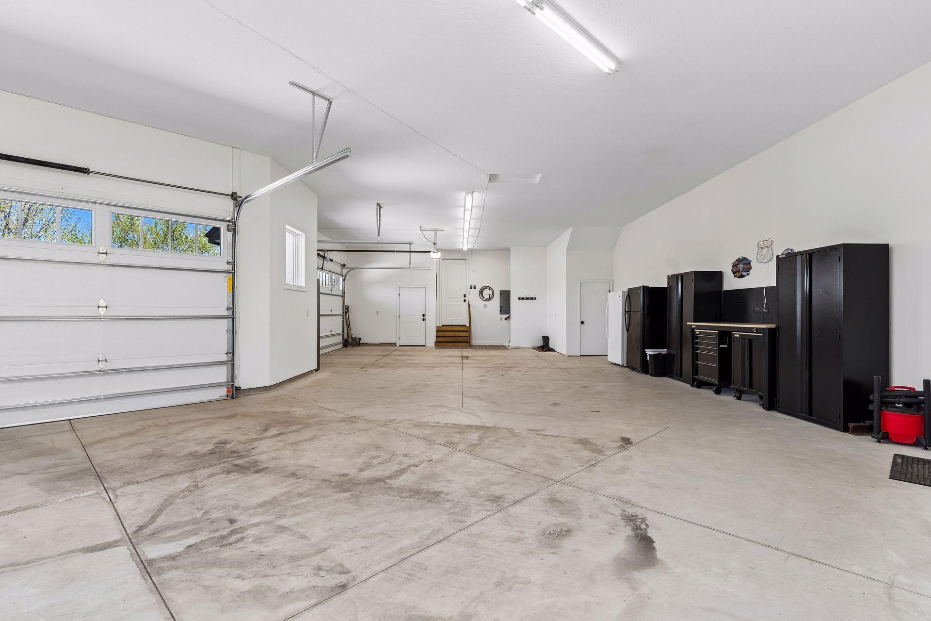 Oversized 5 car heated garage with extra storage, floor drains, workspace and everyday functionality.