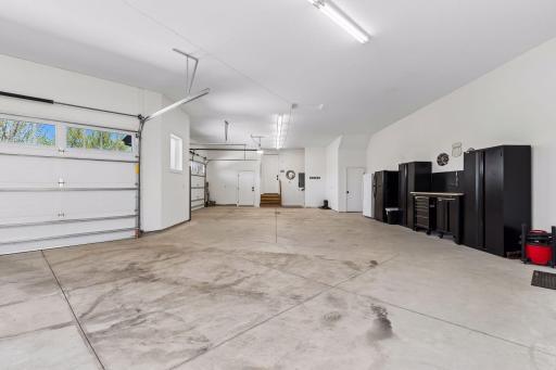 Oversized 5 car heated garage with extra storage, floor drains, workspace and everyday functionality.