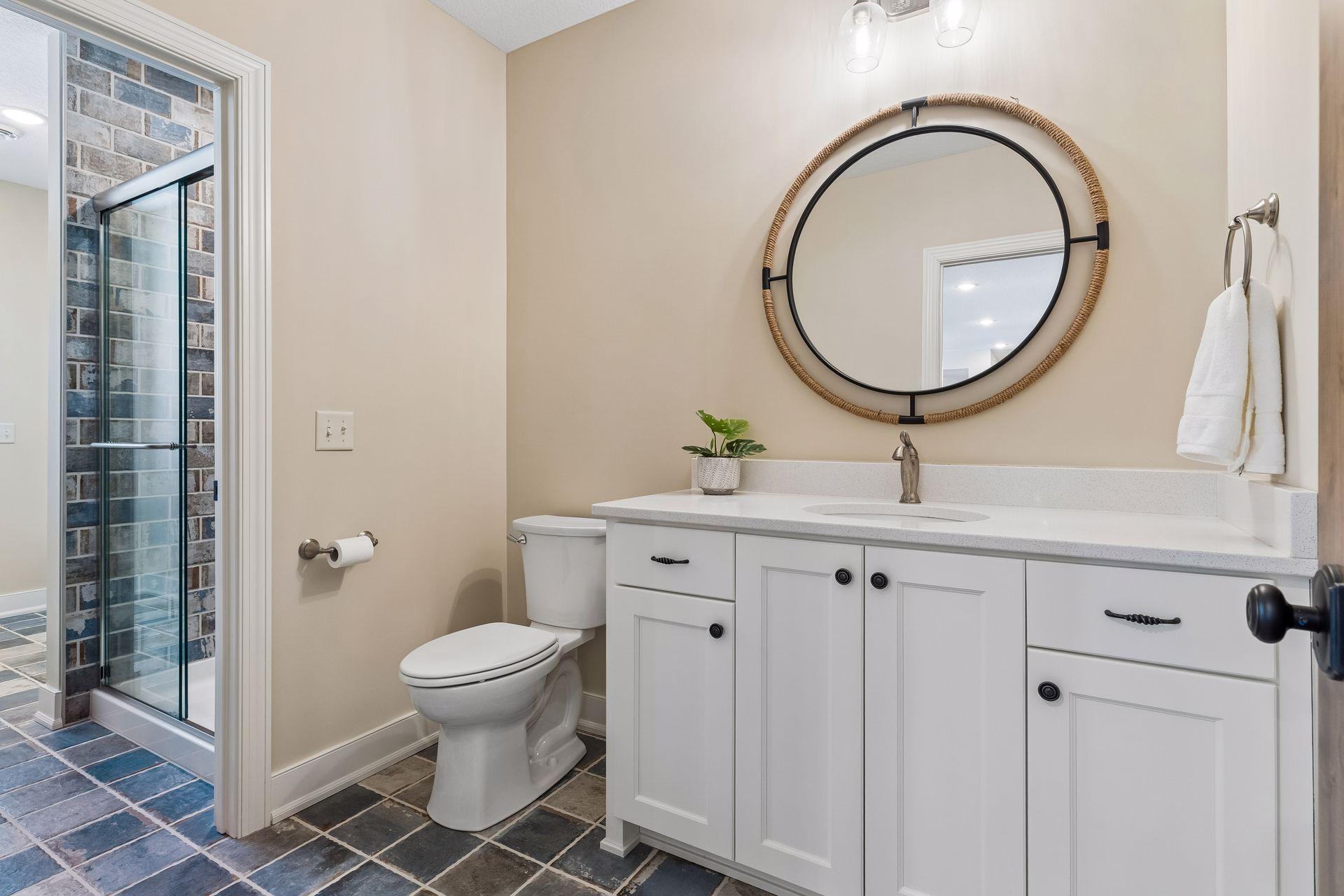 A convenient poolside changing area includes a 3/4 bath, exterior access, built-in bench, hooks, linen storage, and durable finishes—perfect for guests coming in from the pool or outdoor living spaces.