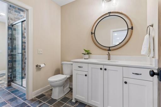 A convenient poolside changing area includes a 3/4 bath, exterior access, built-in bench, hooks, linen storage, and durable finishes—perfect for guests coming in from the pool or outdoor living spaces.