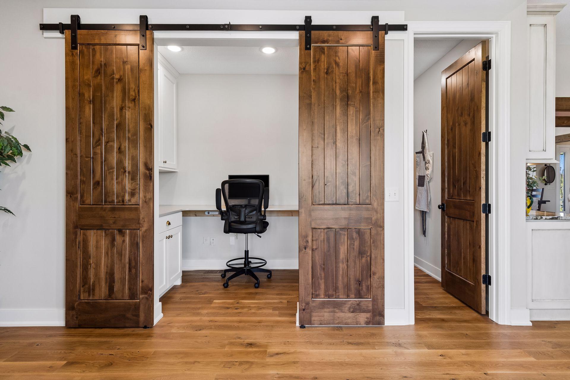 The built-in workstation features custom cabinetry and sliding barn doors, creating a polished and practical space for work, planning, homework, or household organization.