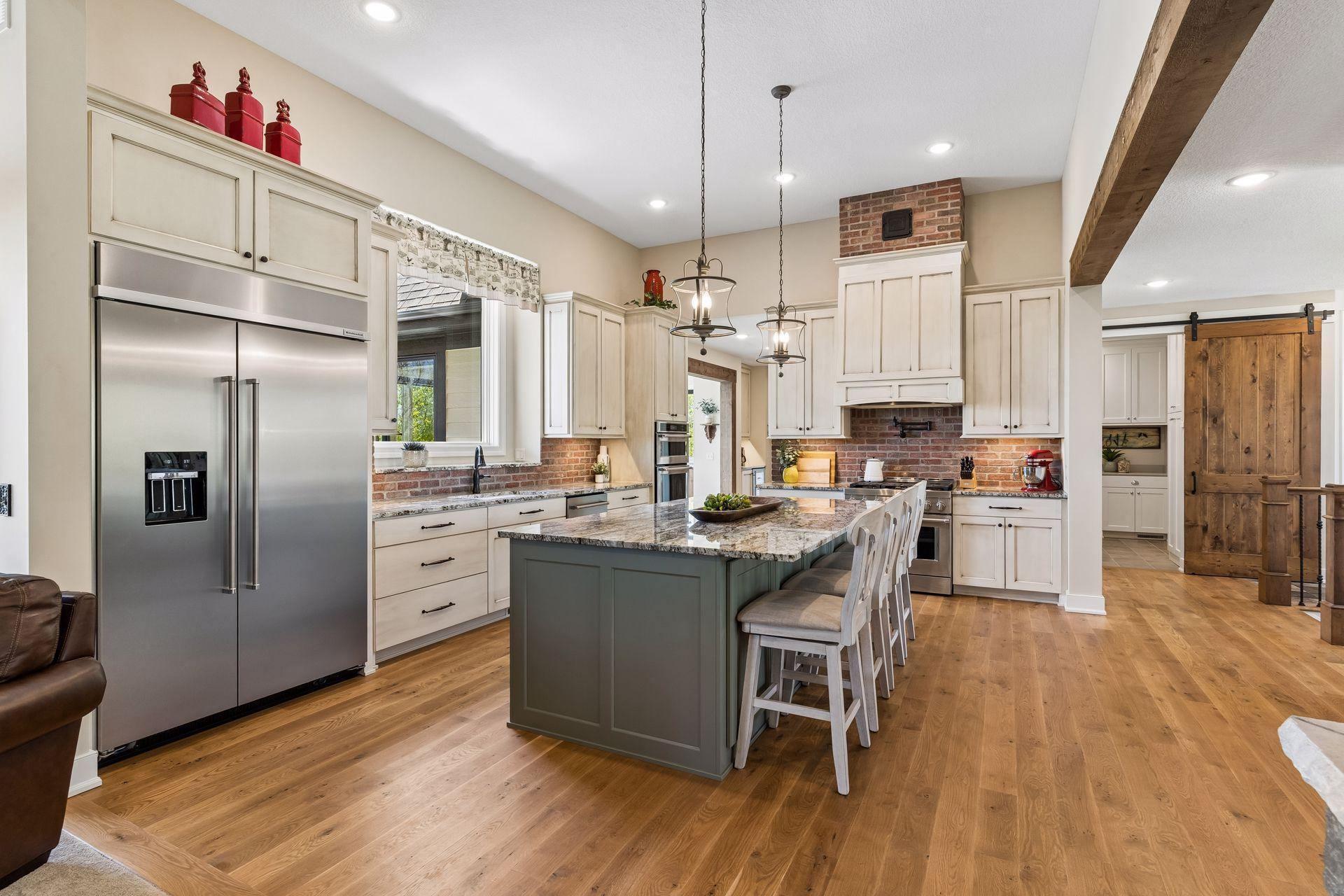 The heart of the home features a spacious gourmet kitchen with custom cabinetry, a large center island, hardwood floors, and an open layout designed for everyday living and effortless entertaining.