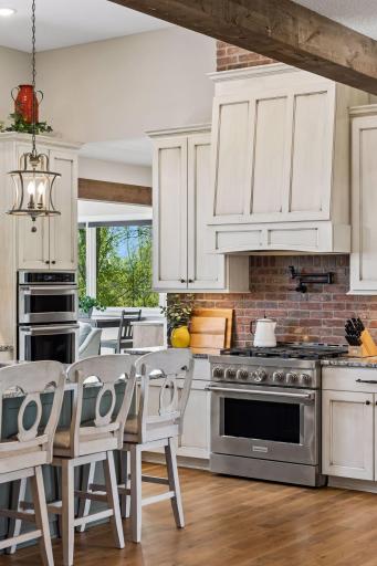 High-end kitchen finishes include custom cabinetry, a brick backsplash, stainless appliances, and thoughtful design details that bring warmth and function to the space.