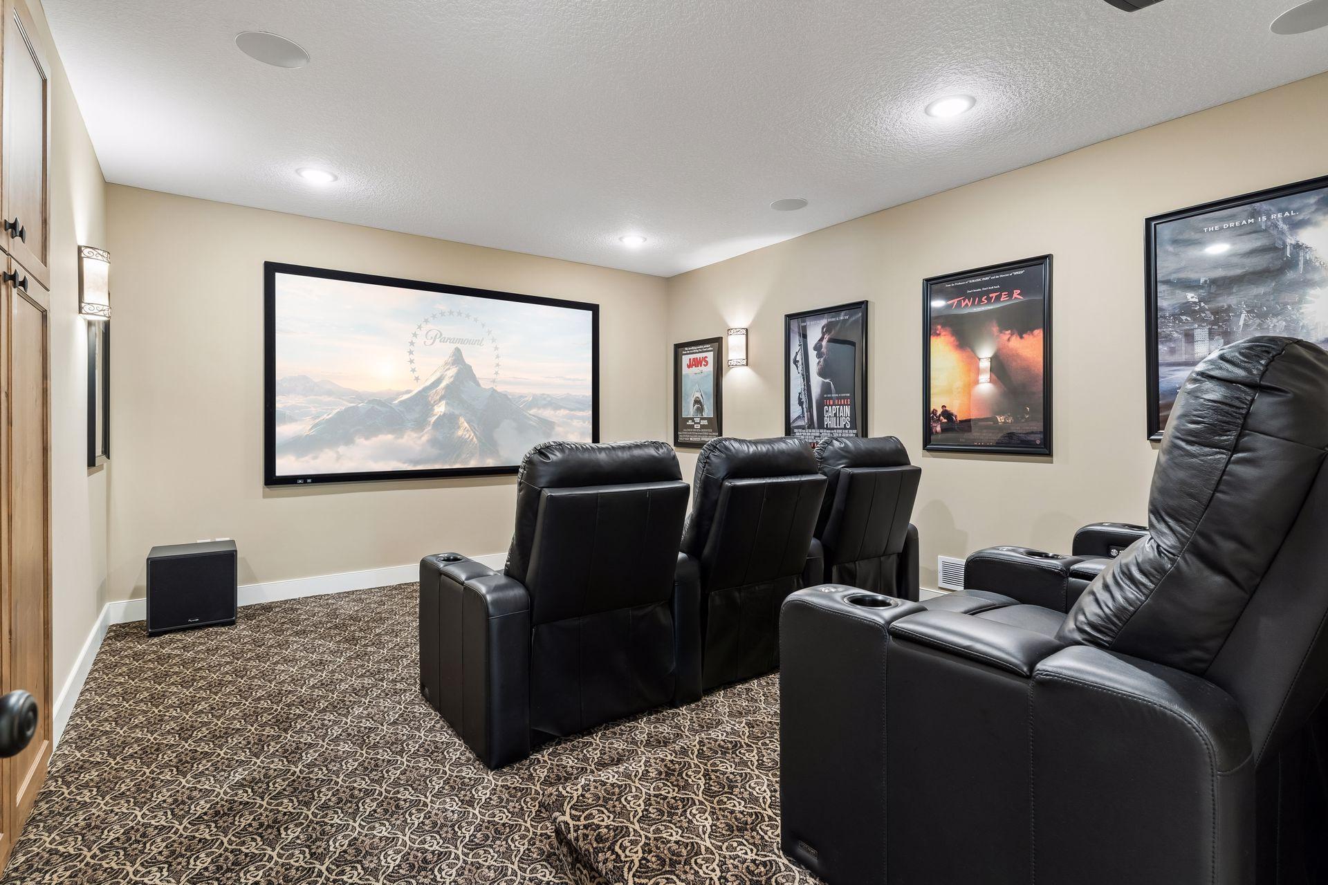 The dedicated theater room delivers a true at-home cinema experience with tiered seating, projector, large screen, and a private setting for movie nights.