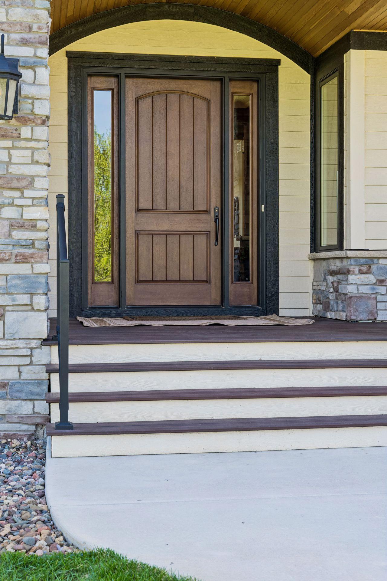 A welcoming covered entry featuring a natural cedar barrel ceiling, rich wood accents, stone details, and a statement front door that blends rustic elegance with luxury craftsmanship.