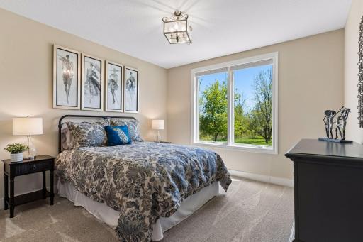 One of two lower-level bedrooms, this comfortable guest room offers natural light, generous space, and convenient access to the nearby full bath.