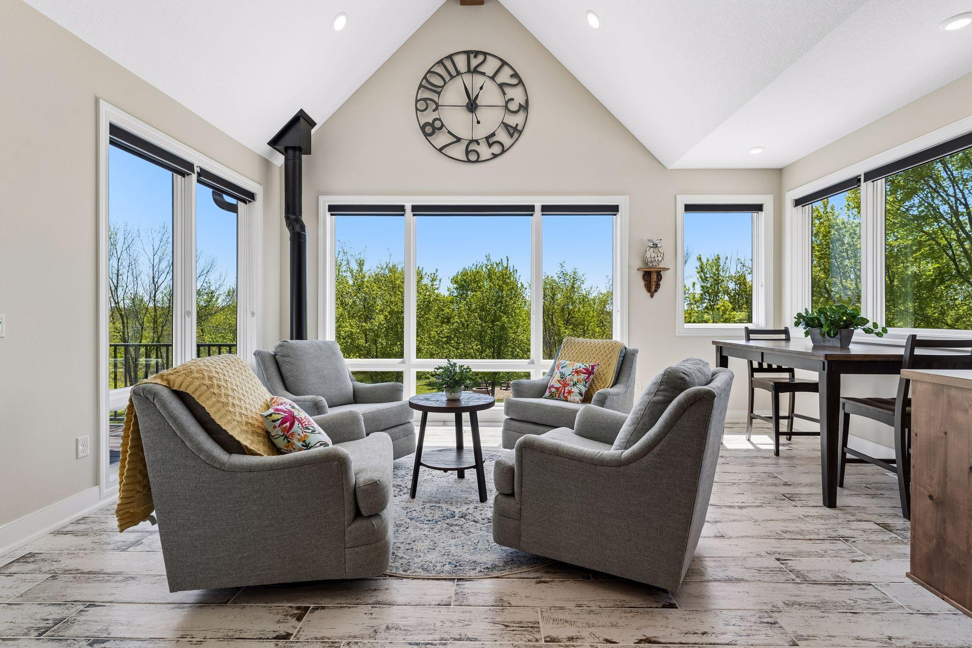 The four-season sunroom offers a bright and peaceful retreat overlooking the pool, complete with a gas stove fireplace, breakfast nook, walls of windows, and direct access to the deck for seamless indoor-outdoor living.