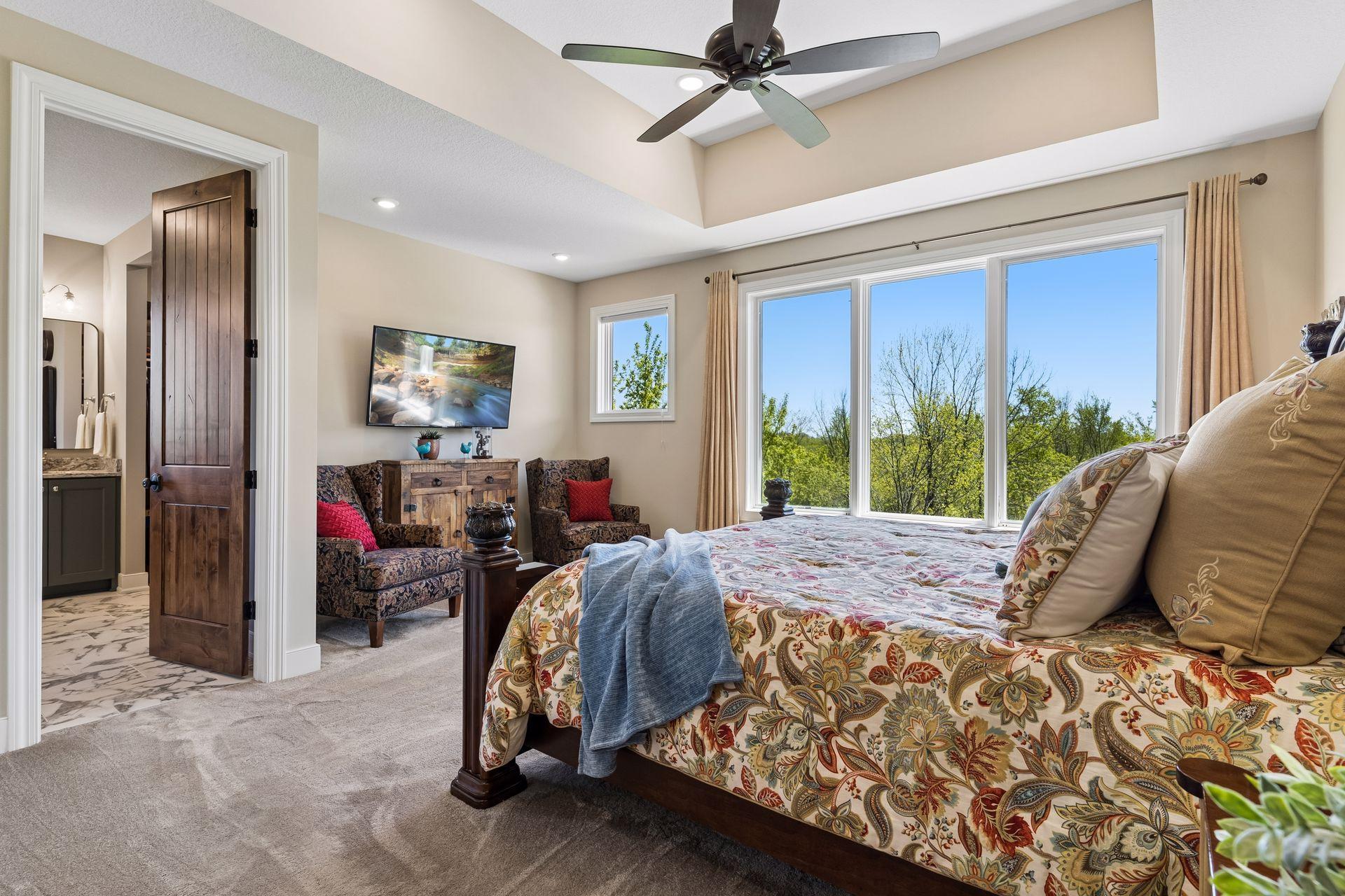 A private sitting area adds flexibility to the primary suite, creating the perfect place to relax, read, or unwind while enjoying views of the surrounding estate grounds.