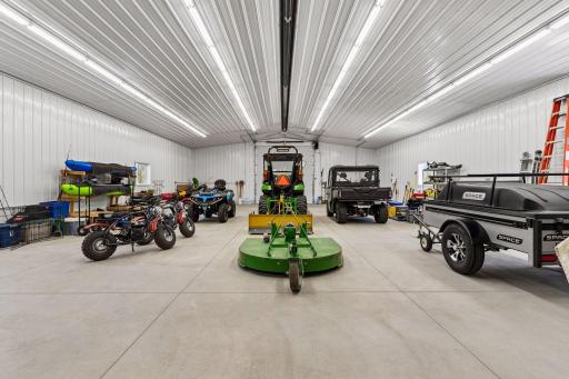 Inside, the outbuilding features radiant heat, insulated concrete floors, floor drain, LED lighting, and workbench space—ideal for business use, storage, hobbies, equipment, or recreational vehicles.