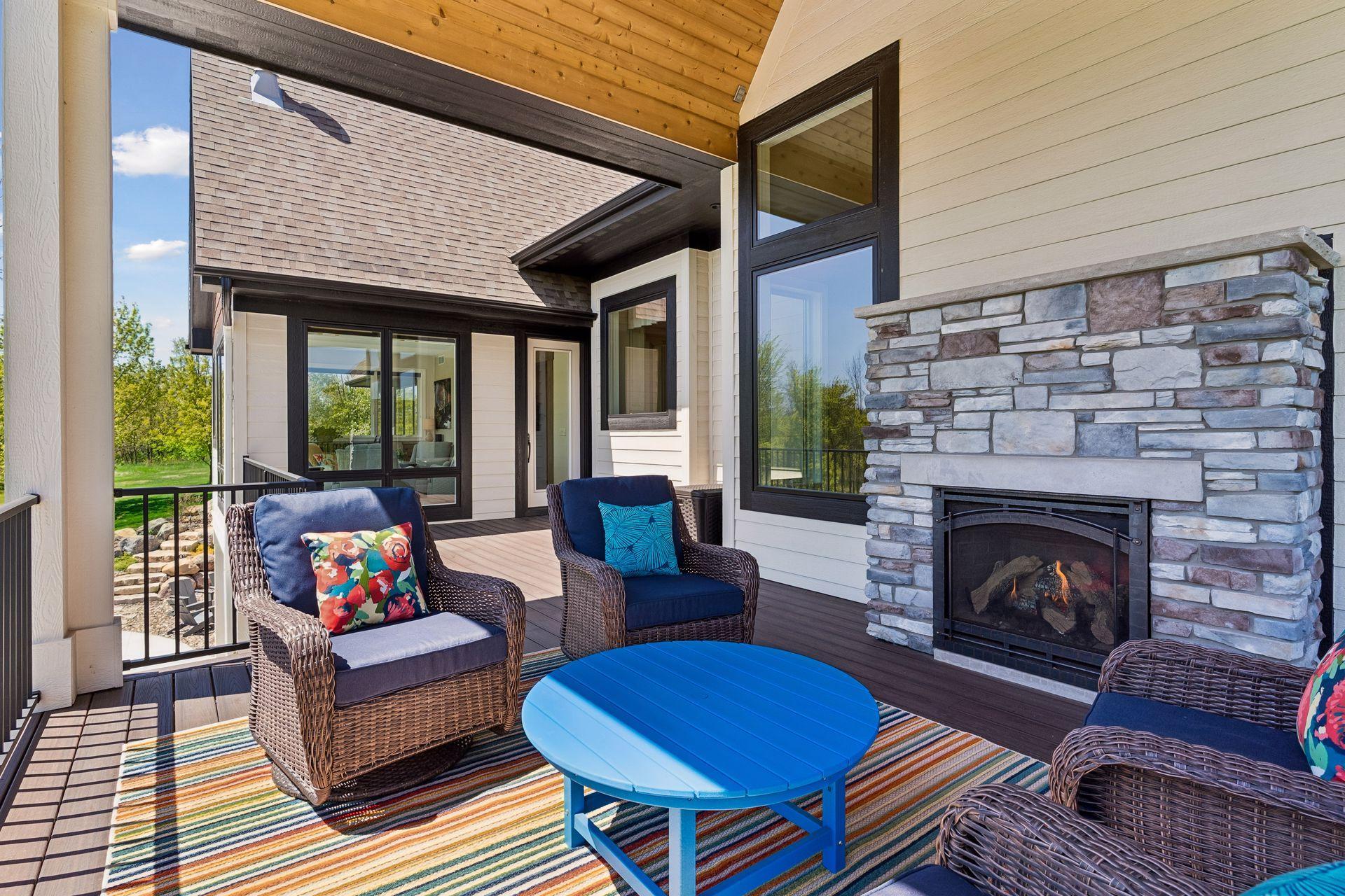 Covered outdoor living area with stone fireplace and warm cedar lined ceiling.