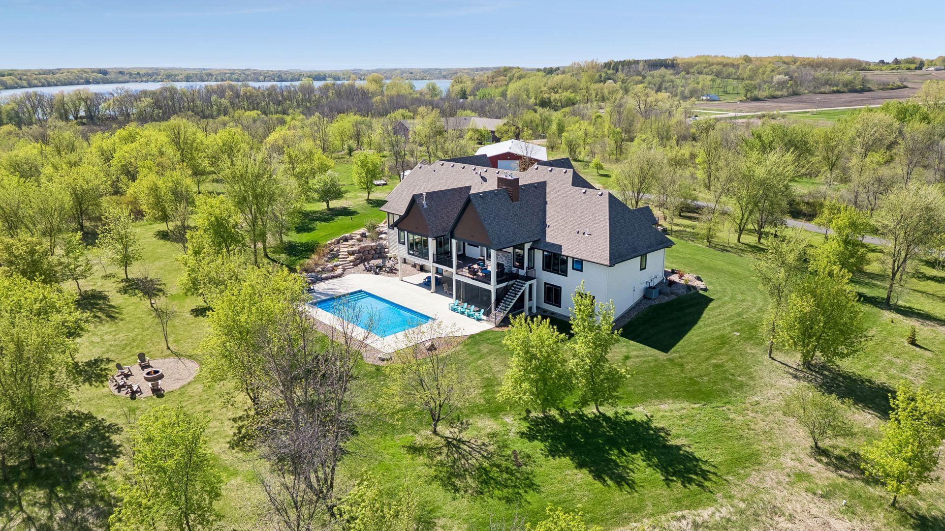 An aerial view of the home’s saltwater pool facing west shows the privacy of the scenic grounds with Mazaska Lake in the background.