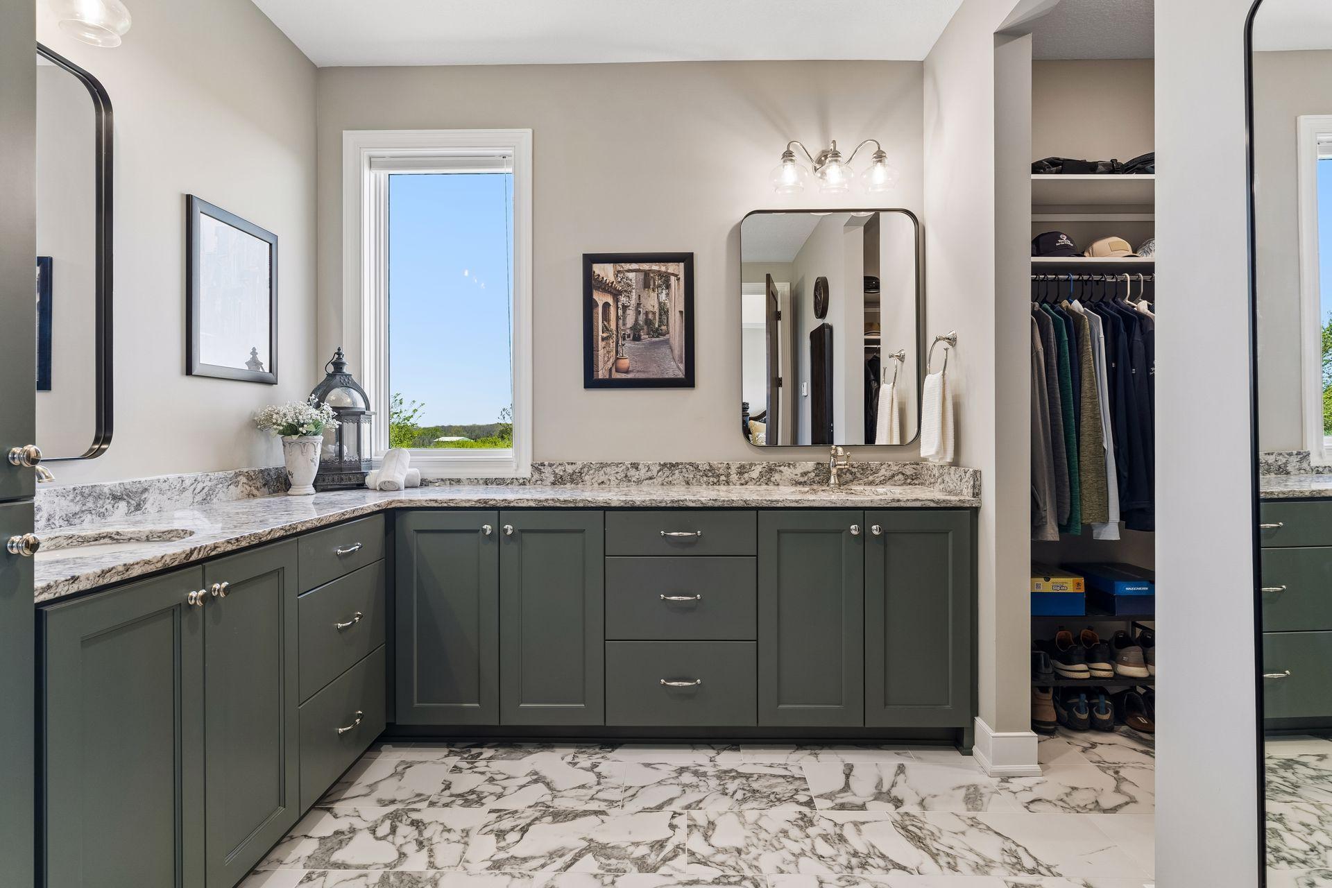 The spa-inspired primary bath offers an extra-long double vanity, abundant cabinetry, a linen cabinet, natural light, and radiant heated floors for everyday luxury.