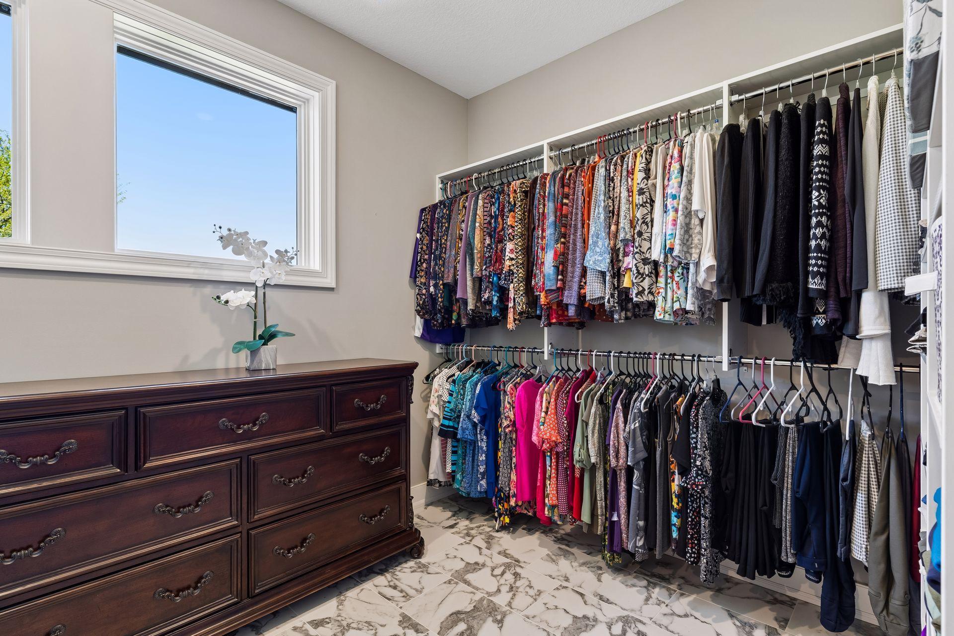 Generous his-and-her closet space includes custom organizers, providing excellent storage and function within the private primary suite.