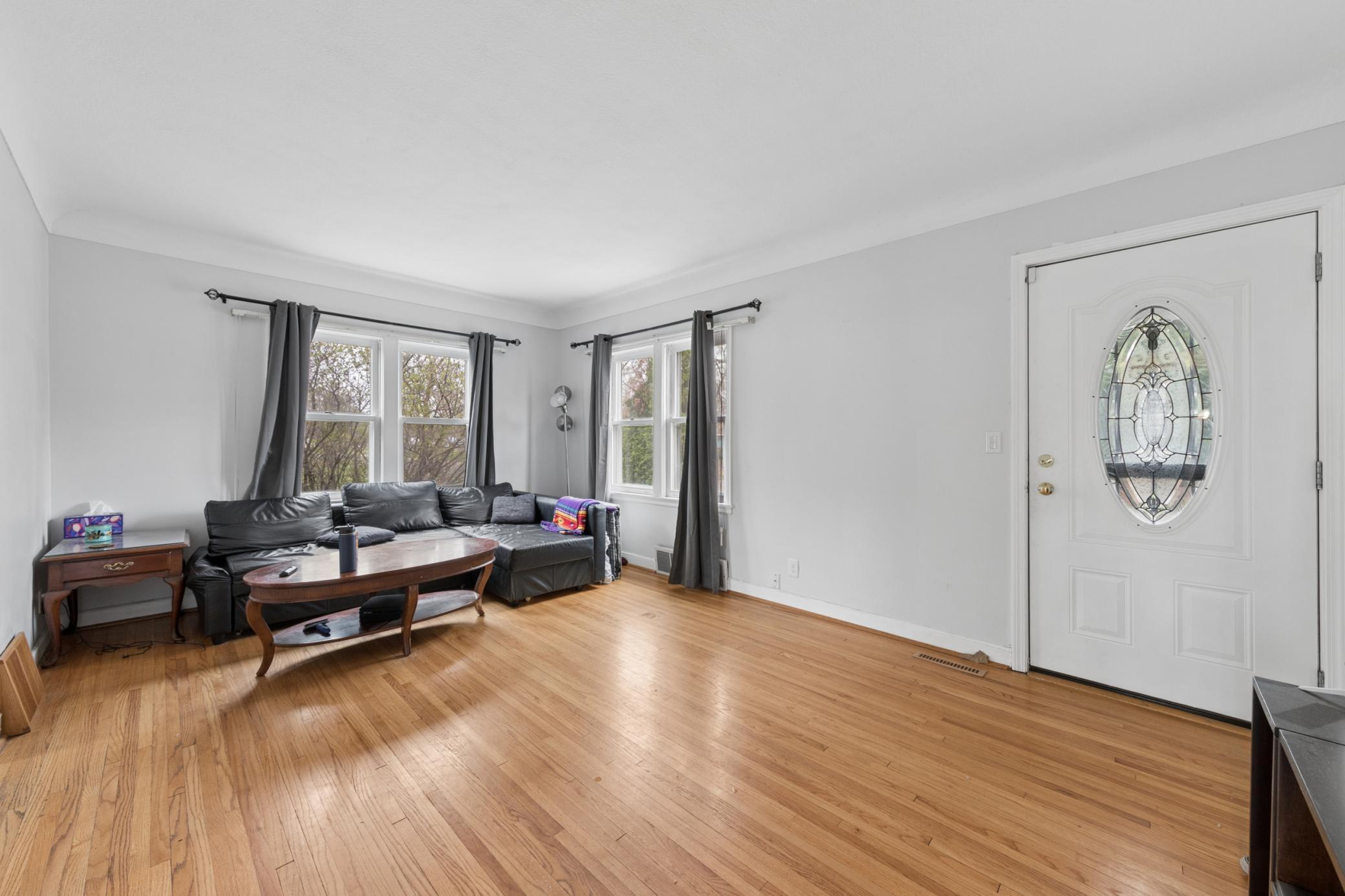 Bright and inviting living room with hardwood floors and large windows bringing in natural light.