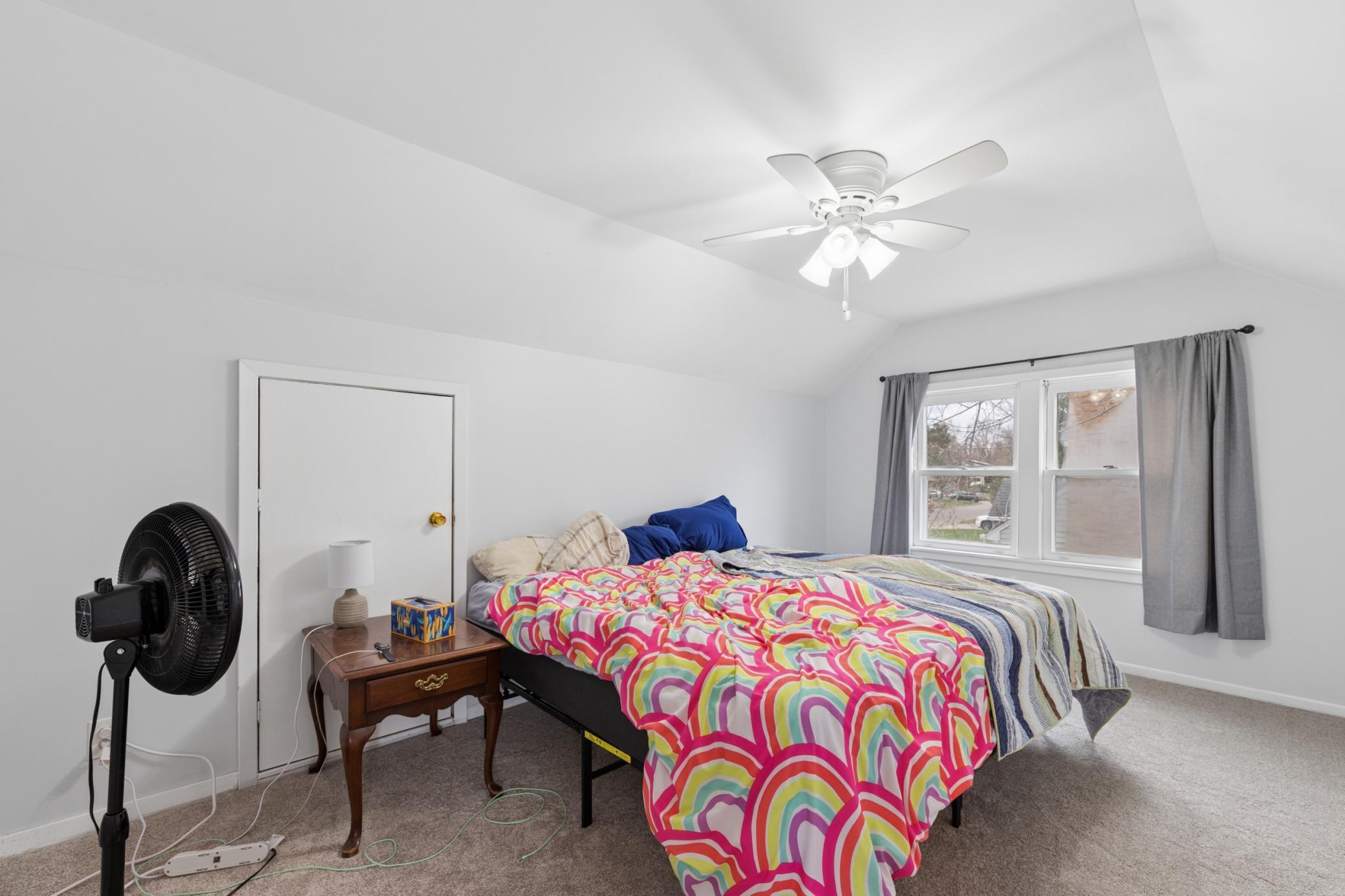 Spacious upper-level bedroom with vaulted ceiling, new carpet, and generous natural light.