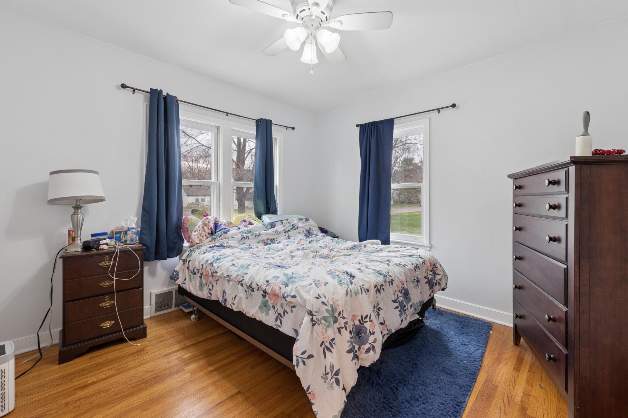 Comfortable main-level bedroom with hardwood floors and abundant natural light.