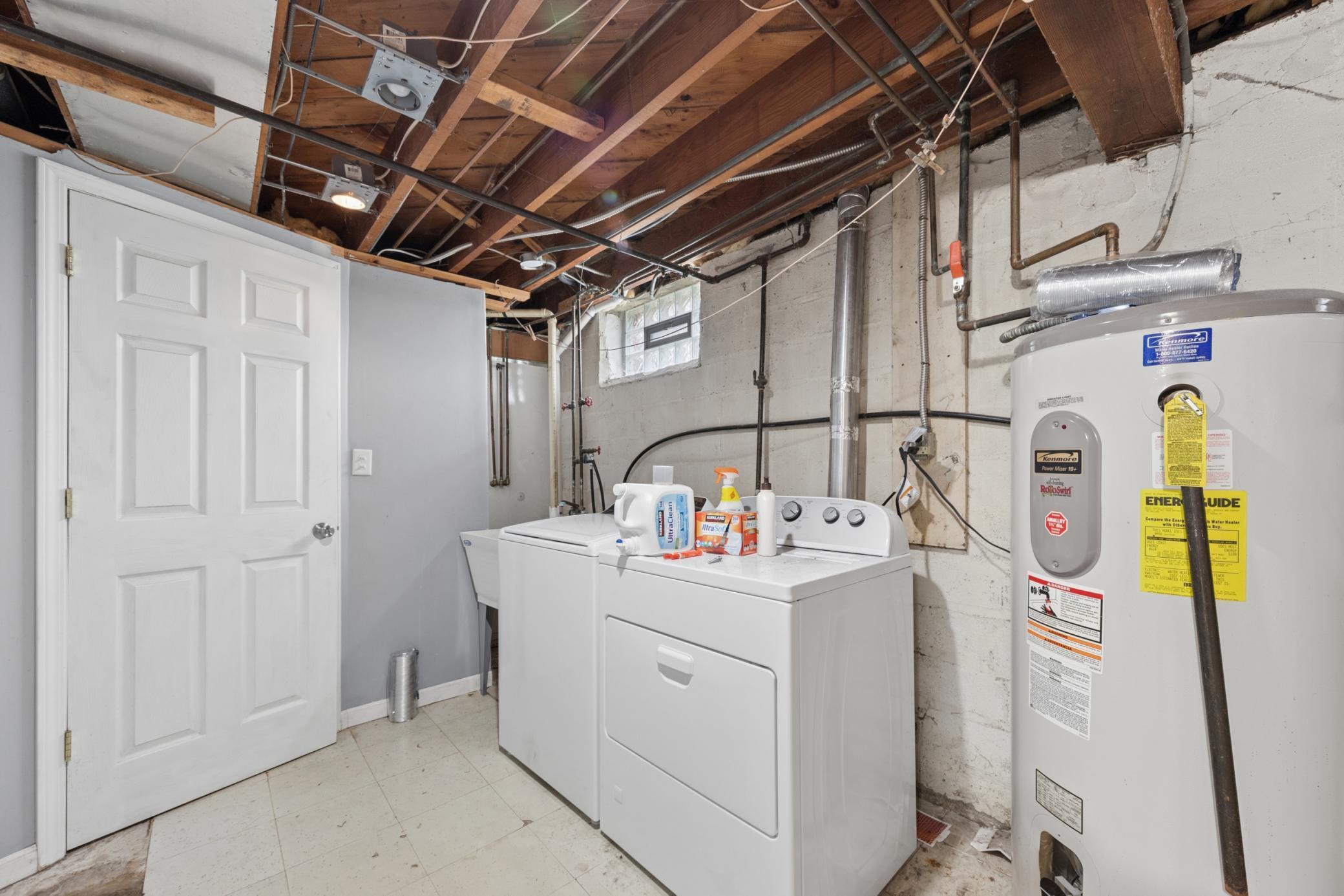 Dedicated laundry area with washer/dryer, utility sink, and ample storage space.