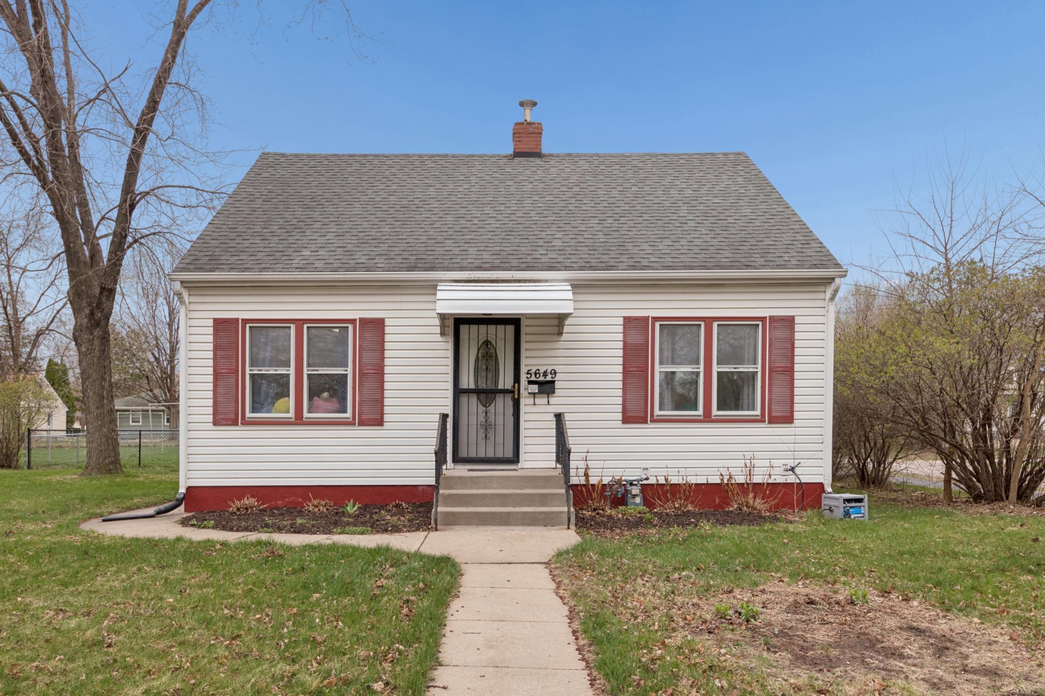 Charming front elevation with classic curb appeal, mature trees, and welcoming entry.