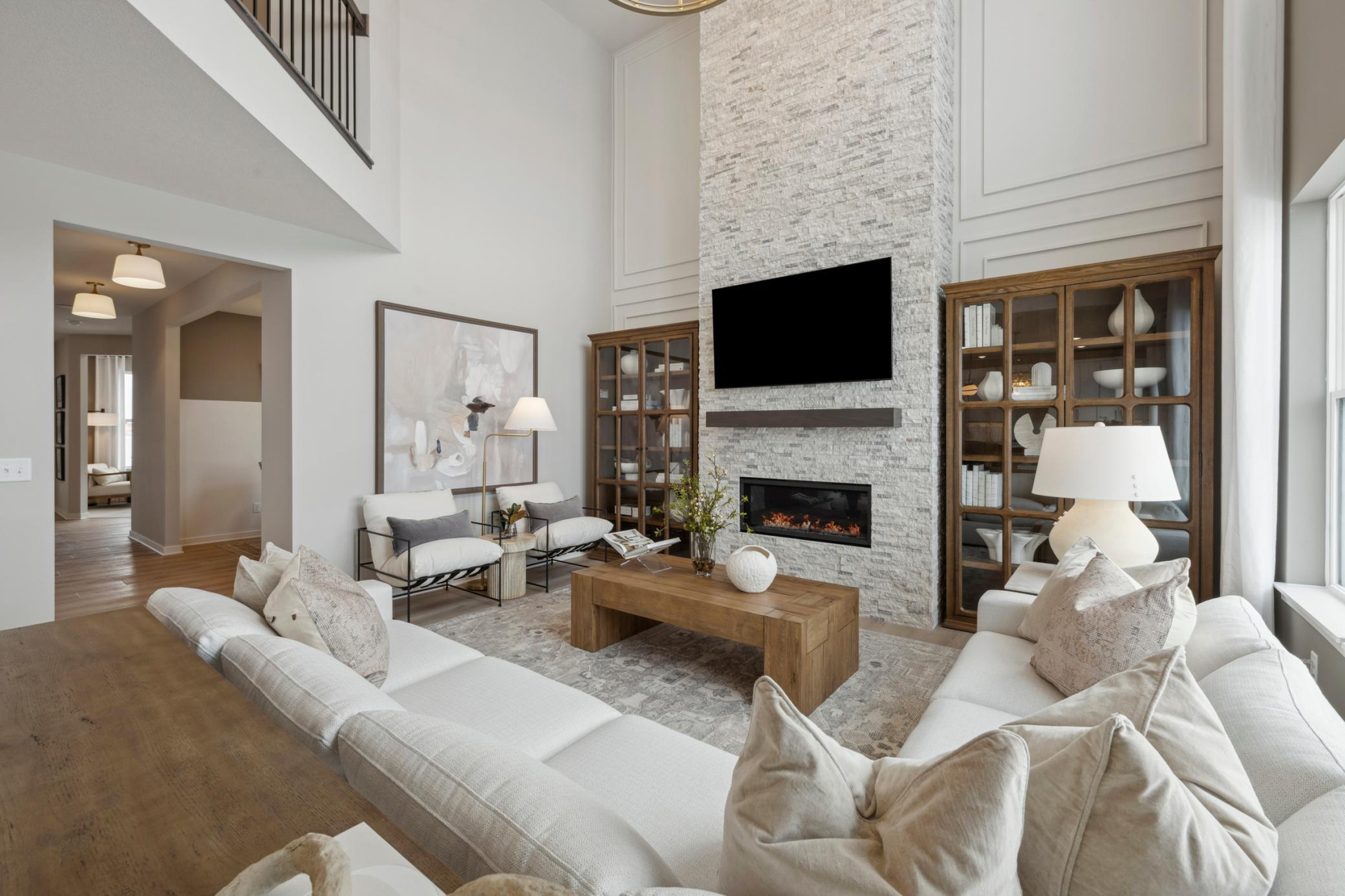 Step into this spacious family room, featuring soaring vaulted ceilings that create an impressive sense of openness and grandeur. The cozy fireplace serves as a warm and inviting focal point, perfect for relaxing evenings or entertaining guests in