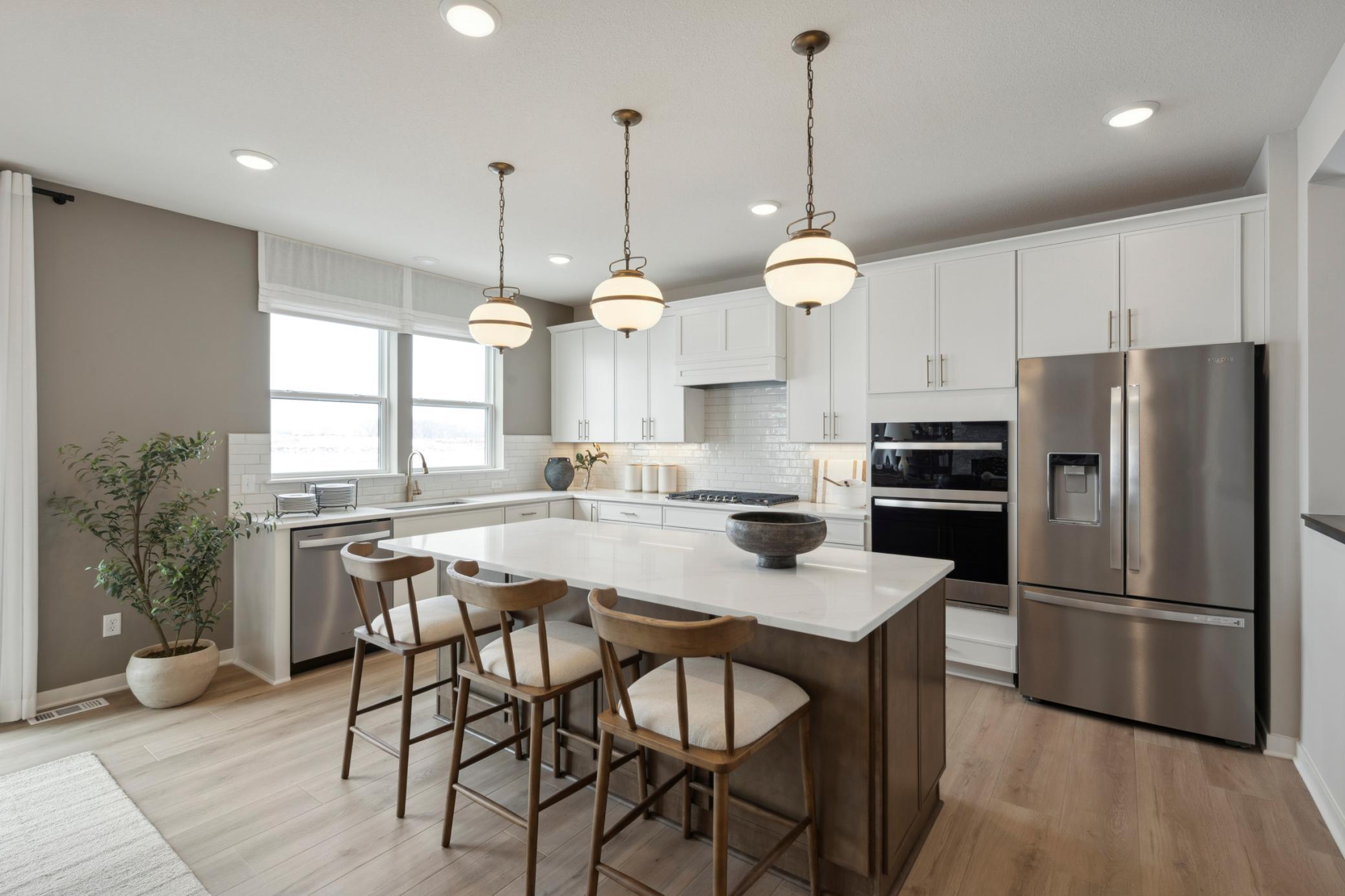 Central island offers additional prep space, seating, and storage, making it the heart of the home.