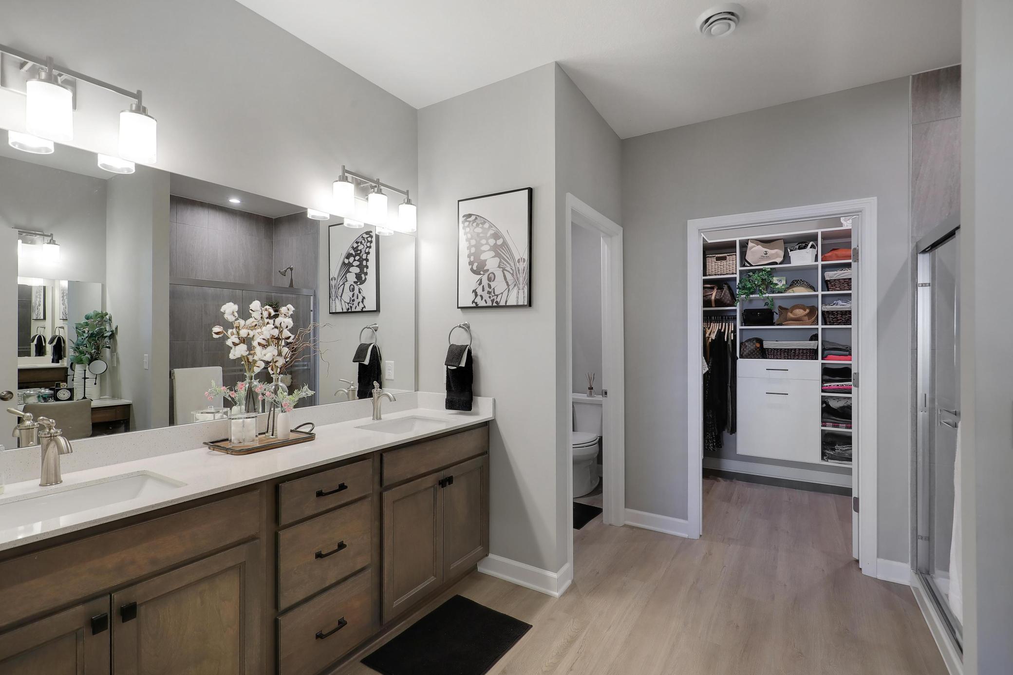 Primary Bathroom with dual sinks and walk-in closet