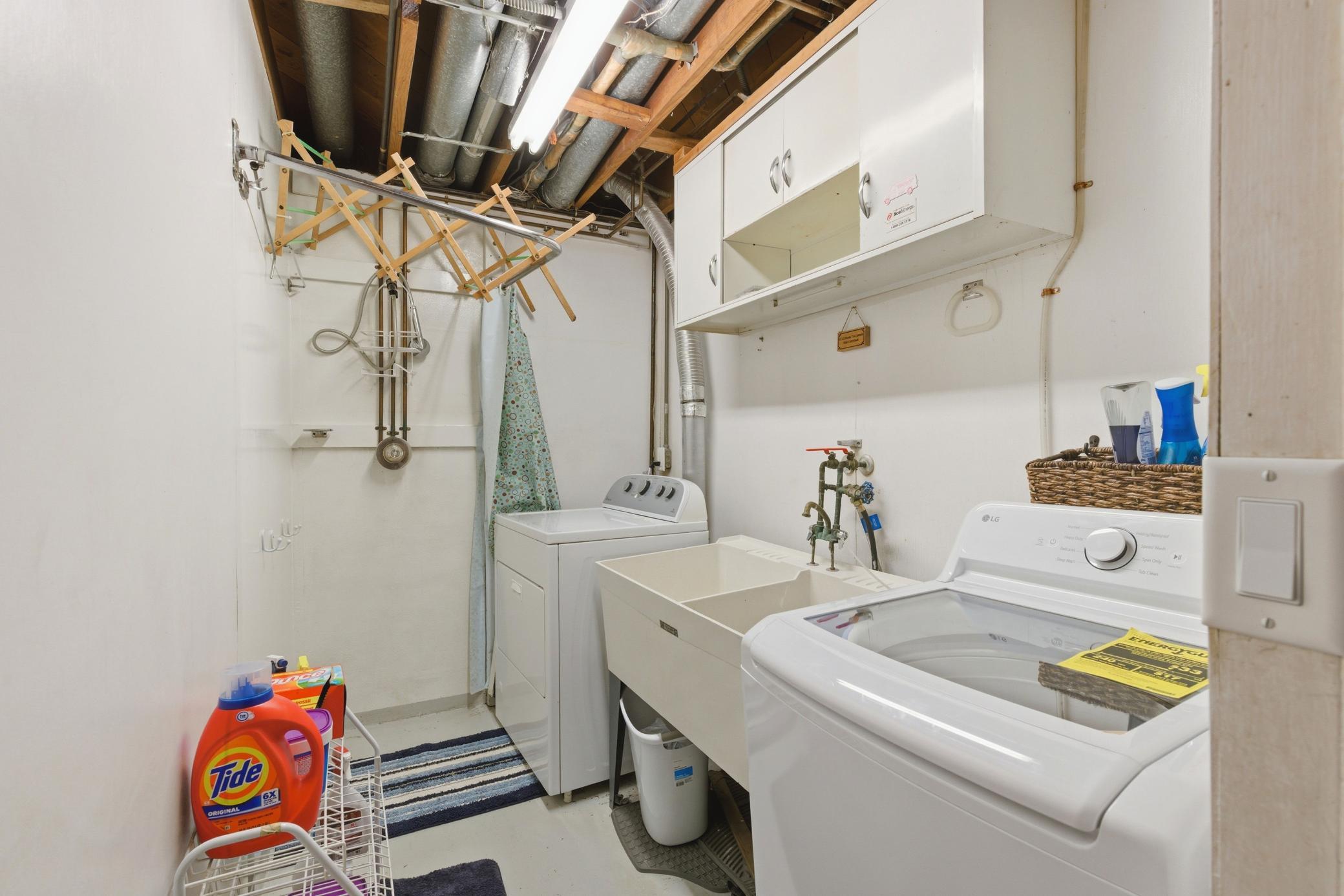 Laundry has double sinks and storage.
