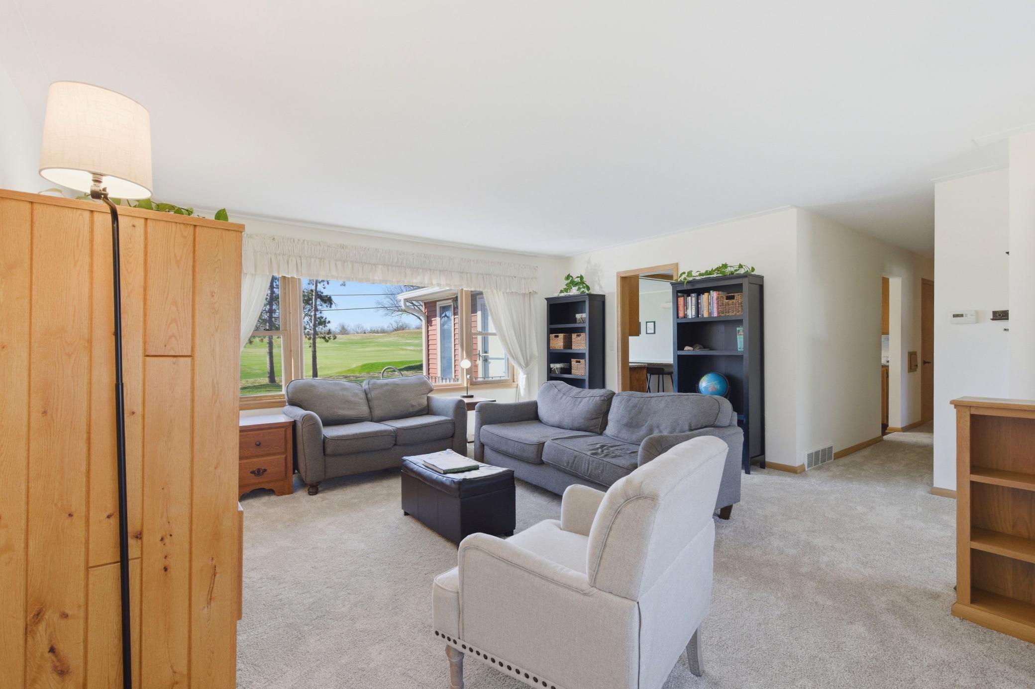Generous living room with fresh carpet.