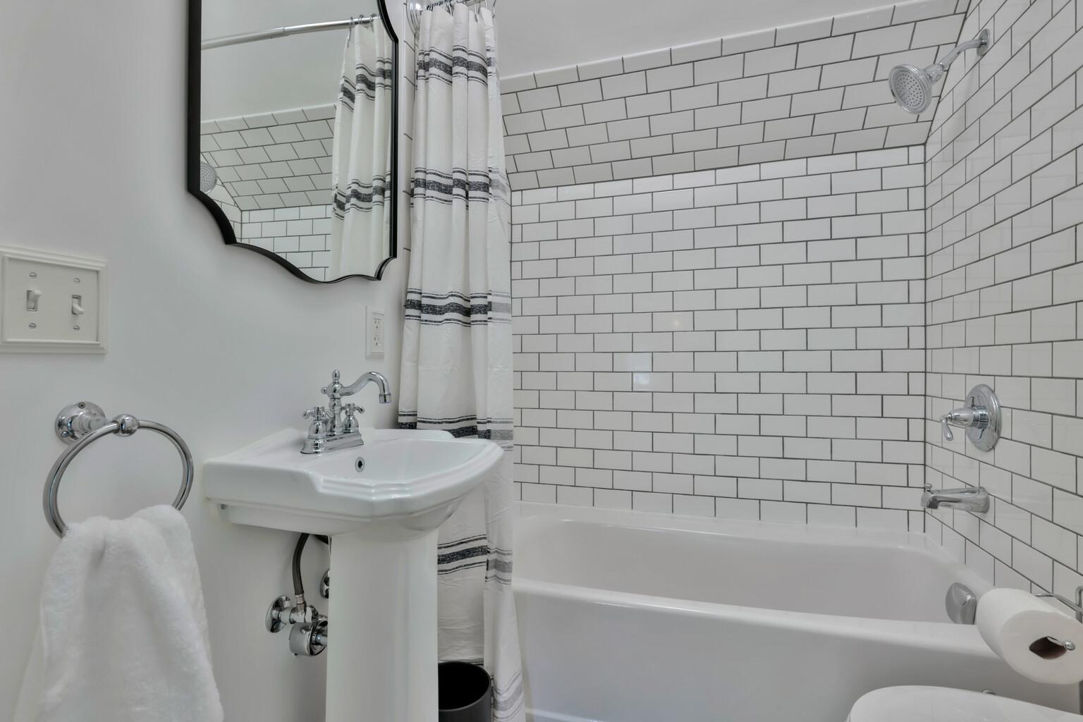 Bright 3rd-floor bath with heated flooring and classic subway tile. Features a pedestal sink and clean, modern finishes for a fresh, updated look.