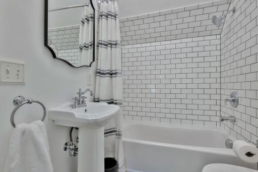 Bright 3rd-floor bath with heated flooring and classic subway tile. Features a pedestal sink and clean, modern finishes for a fresh, updated look.