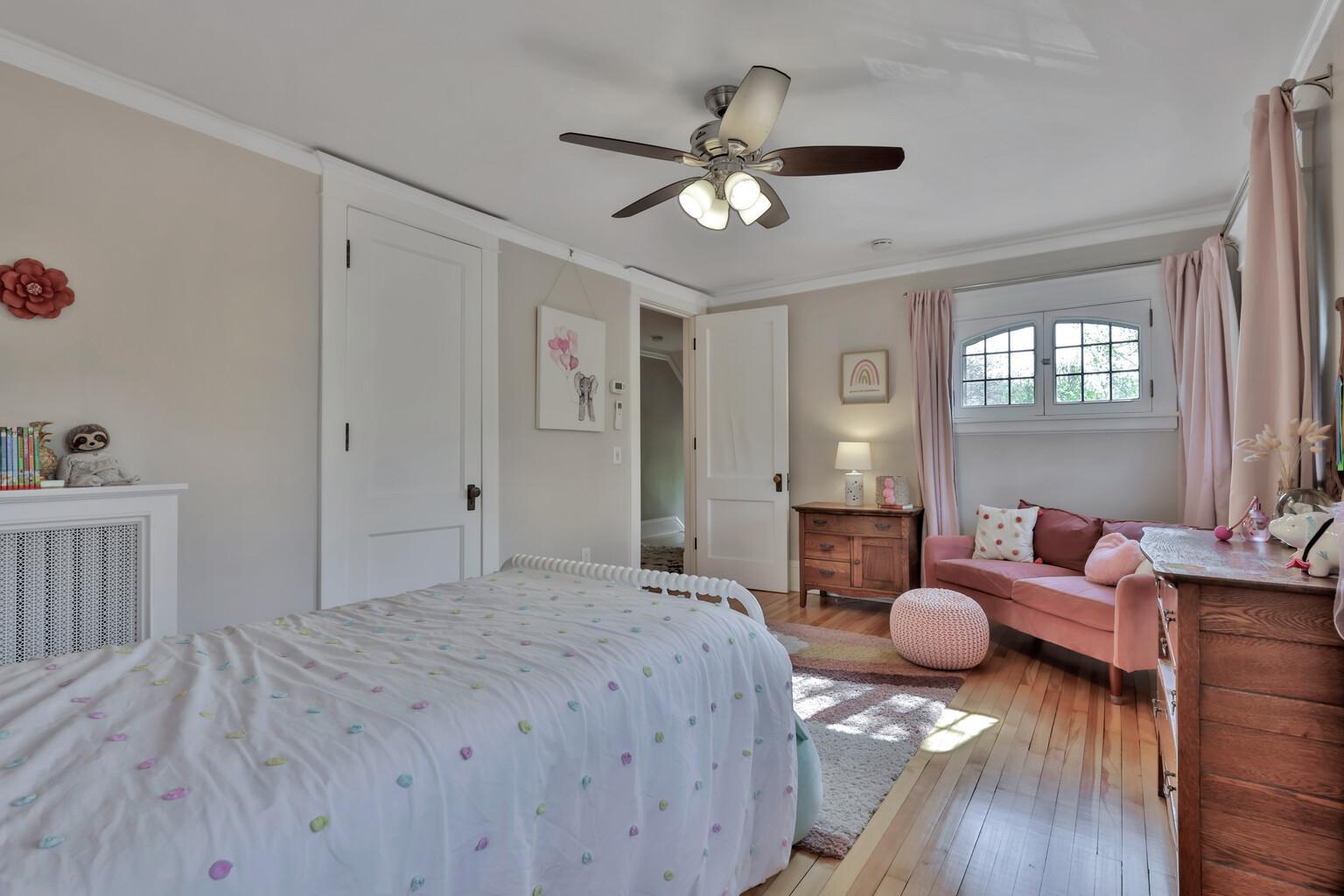 Generously sized second bedroom bursting with charm! Highlighted by unique arched windows and crown molding, this sun-filled space offers a perfect blend of historic soul and comfort.