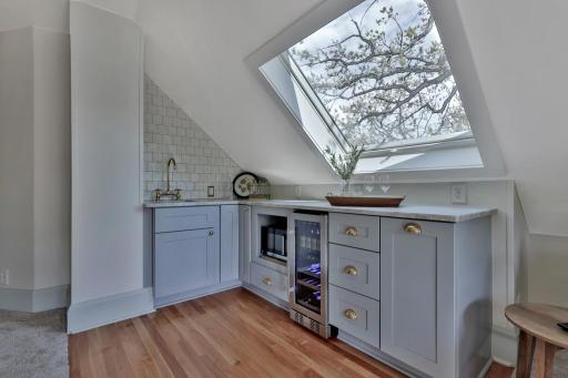 The ultimate 3rd-floor sanctuary! Designer wet bar, chiller, & microwave built-ins make hosting a breeze. Sun-drenched by a large skylight with effortless window access to a serene treetop deck.